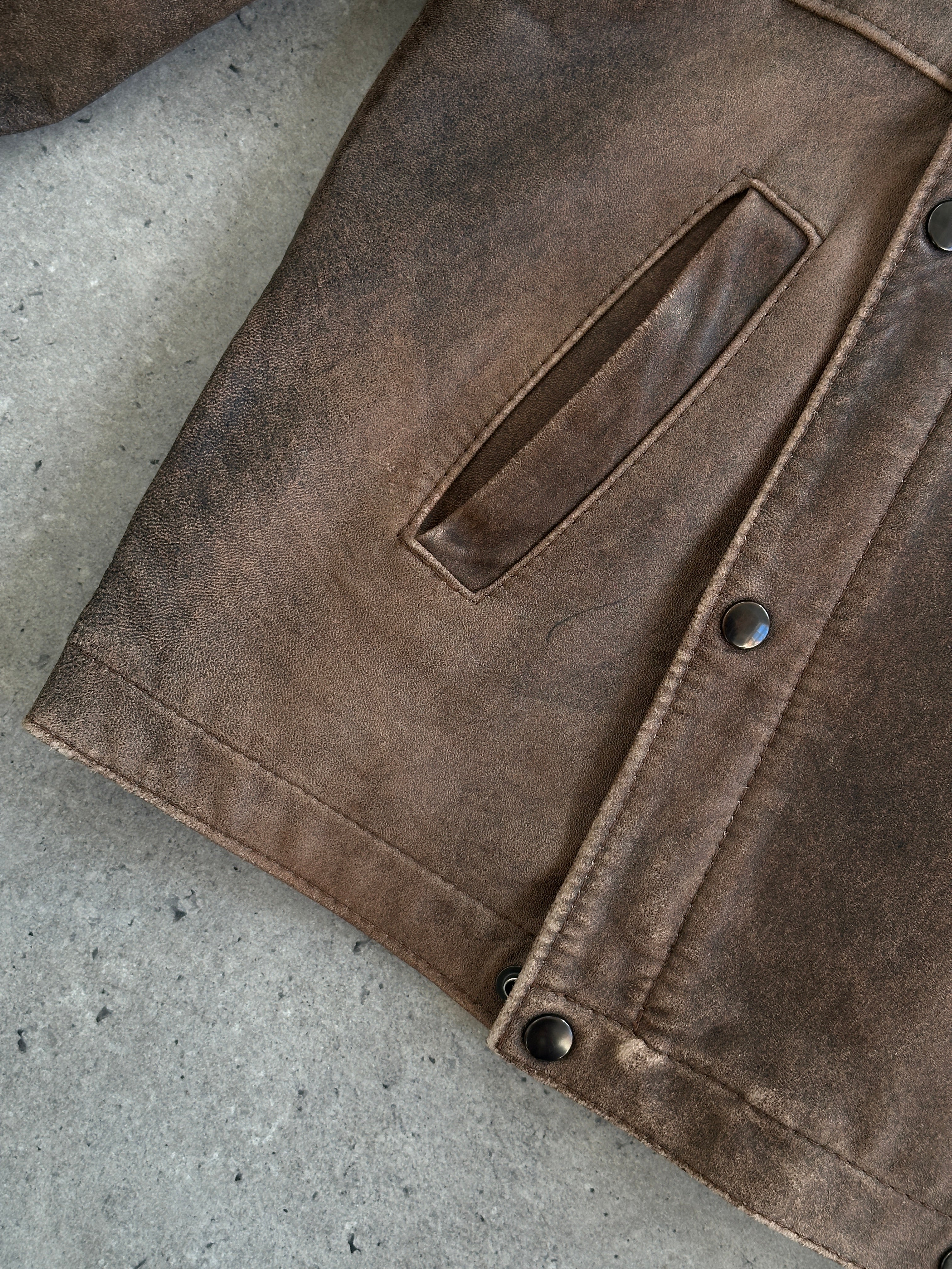 Vintage British aged leather biker jacket in size M/L, featuring rugged design and classic motorcycle style.
