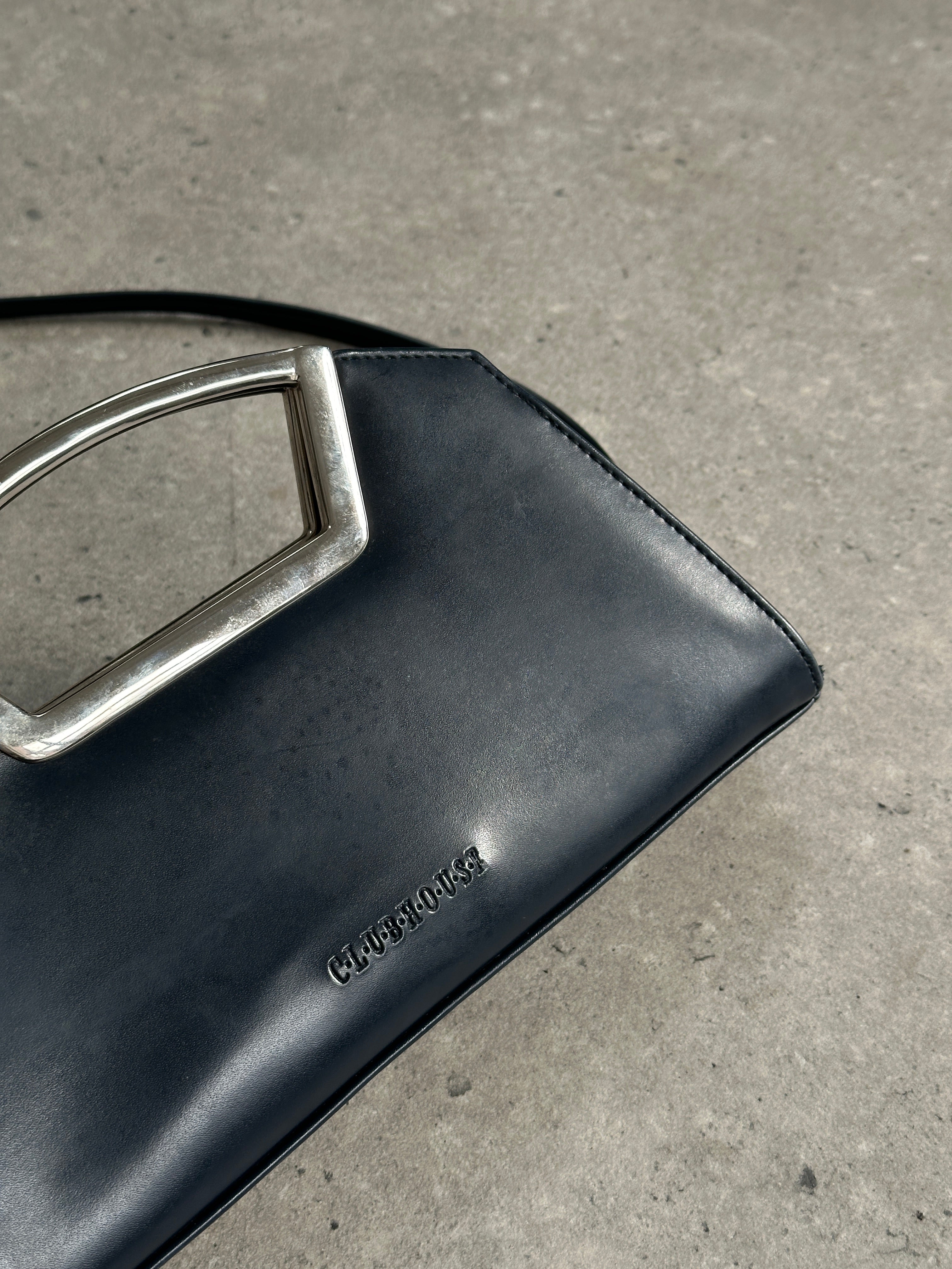 Vintage leather chrome crossbody clutch bag with adjustable strap and classic design, perfect for stylish everyday use.