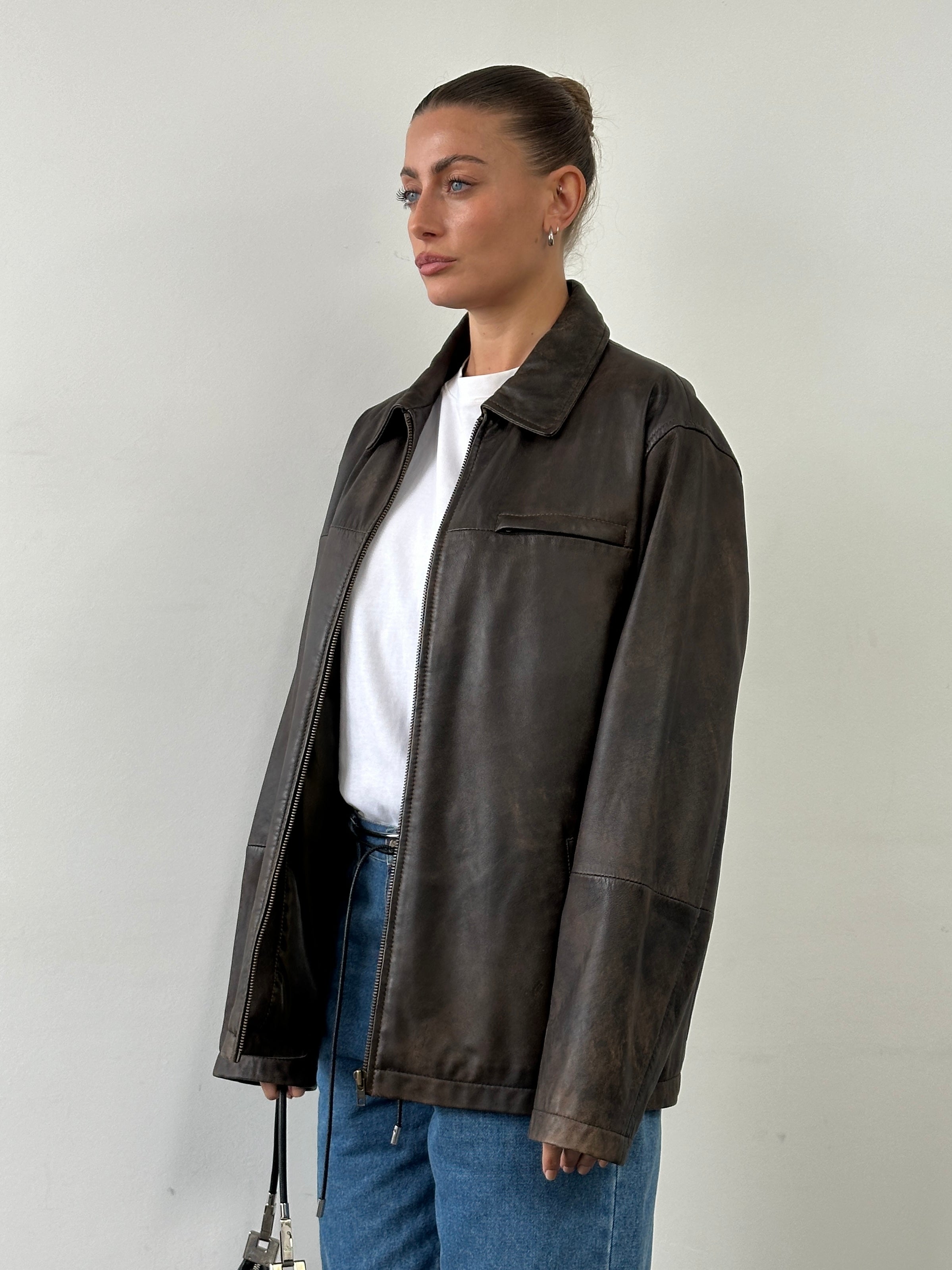 Vintage minimal aged leather jacket in XL size, showcasing distressed leather and classic design with a sleek, timeless look.