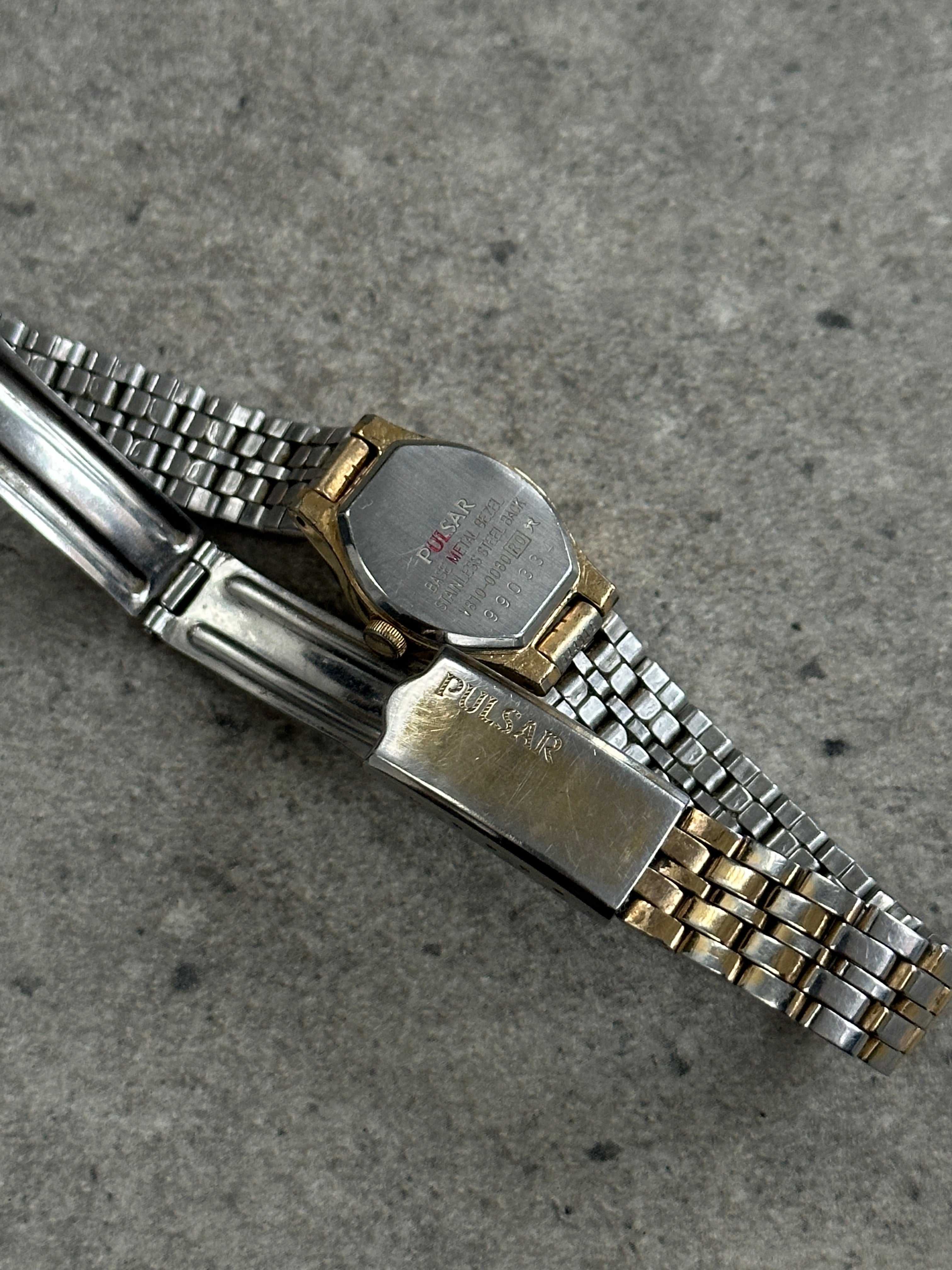Pulsar 1990s two-tone round quartz watch with silver and gold finish, featuring a sleek dial and stainless steel band.