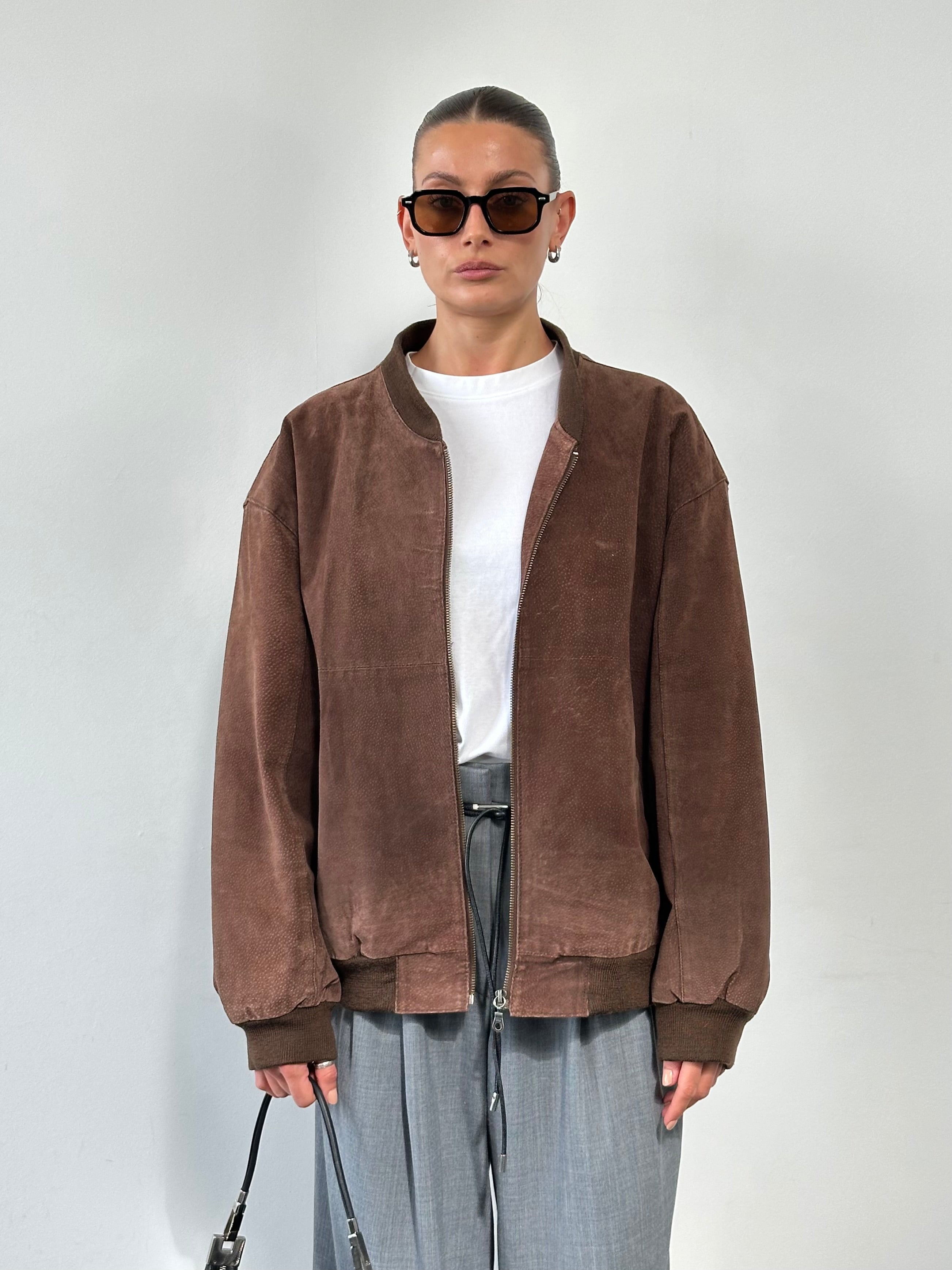 Vintage suede bomber jacket in XL/XXL, featuring classic design, fitted collar, and stitched details, displayed on a hanger.