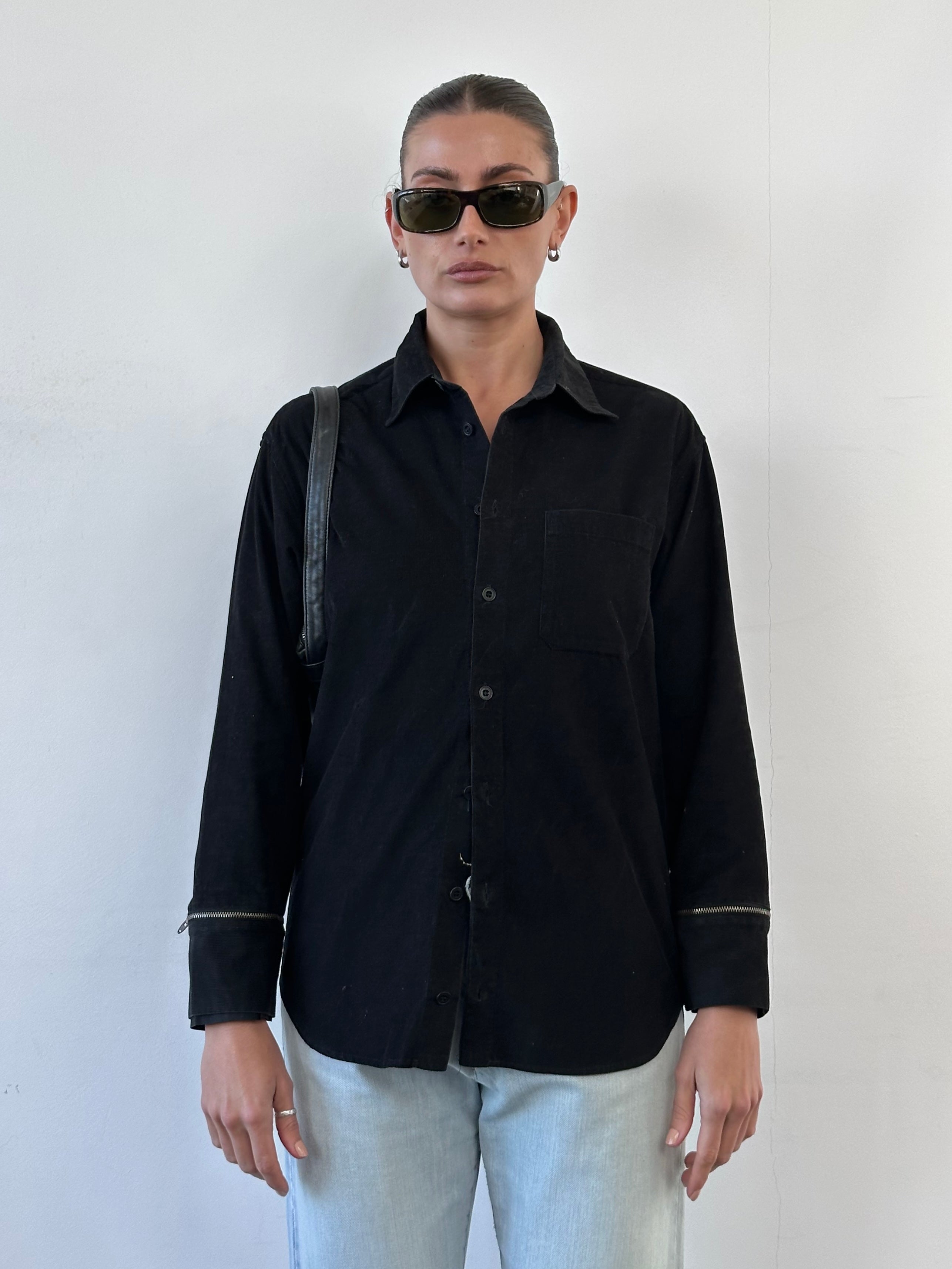 Versace Versus 00s corduroy zip shirt in black, front view showing collar, zipper detail, and long sleeves.