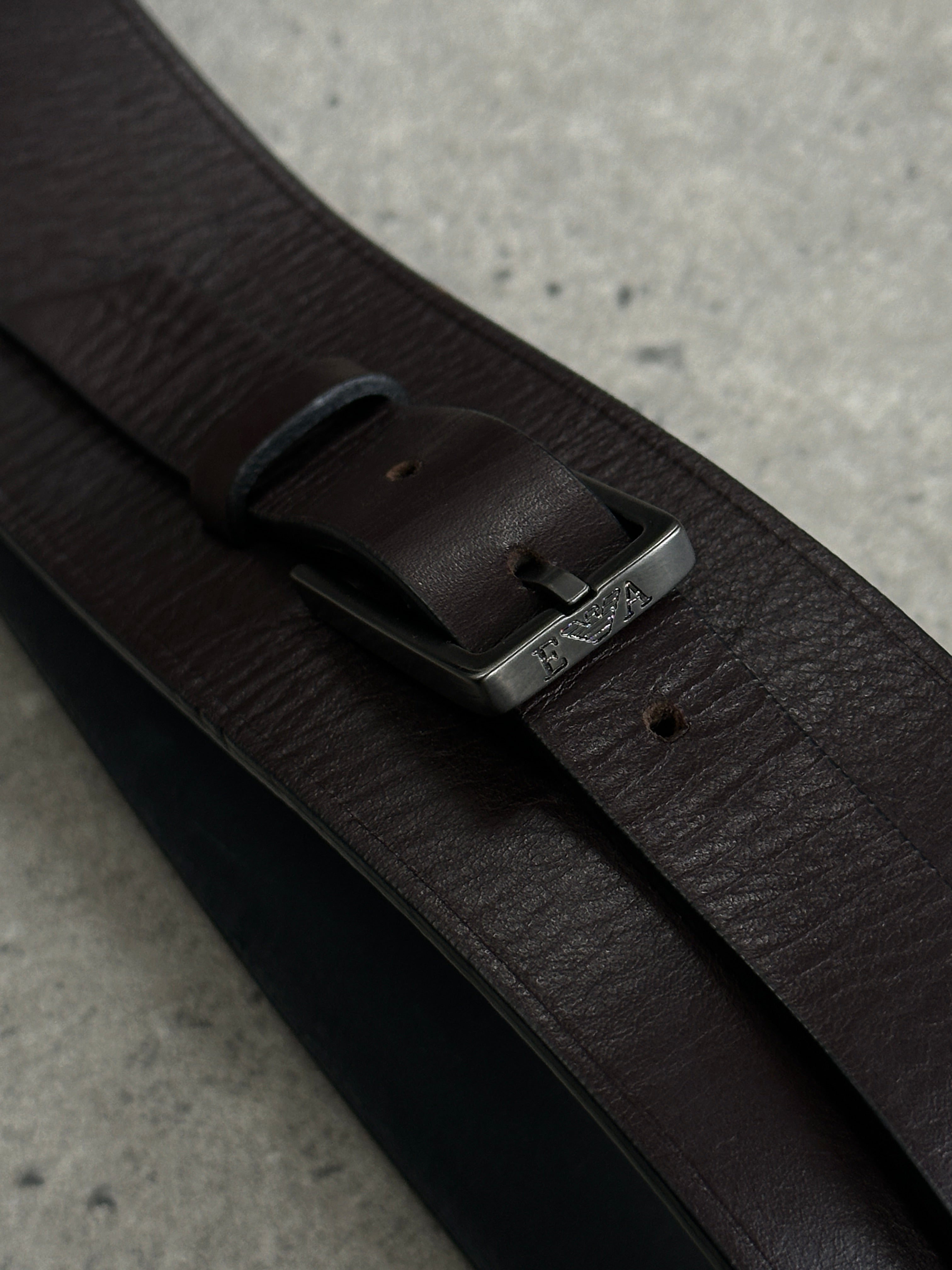 Emporio Armani leather belt with EA buckle, 2000s style, W30–32, showcasing the sleek black strap and signature branding.