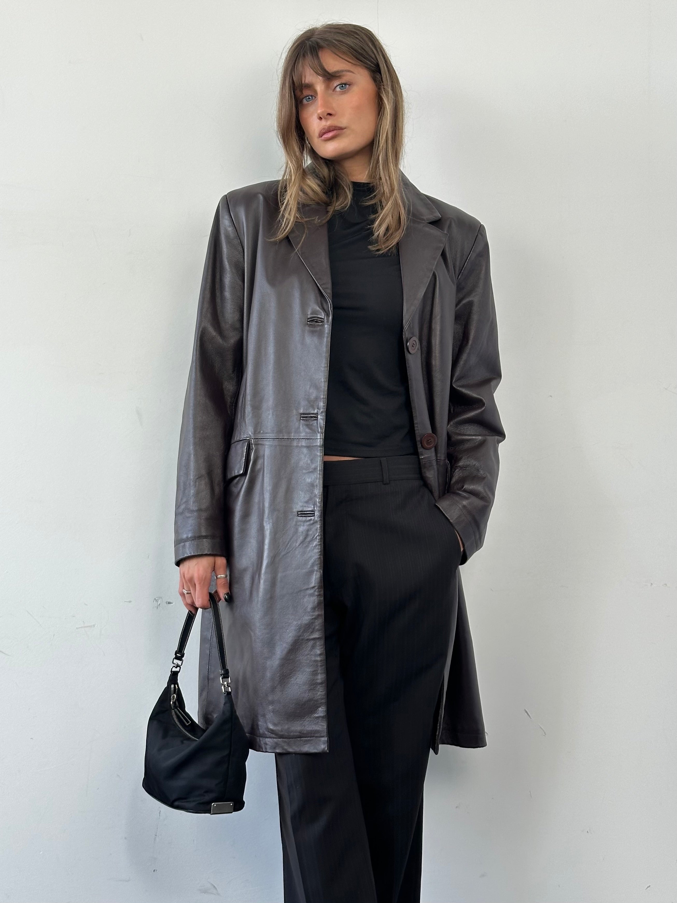 Vintage minimal leather trench coat jacket in size L, featuring classic design and sleek leather material displayed on a hanger.