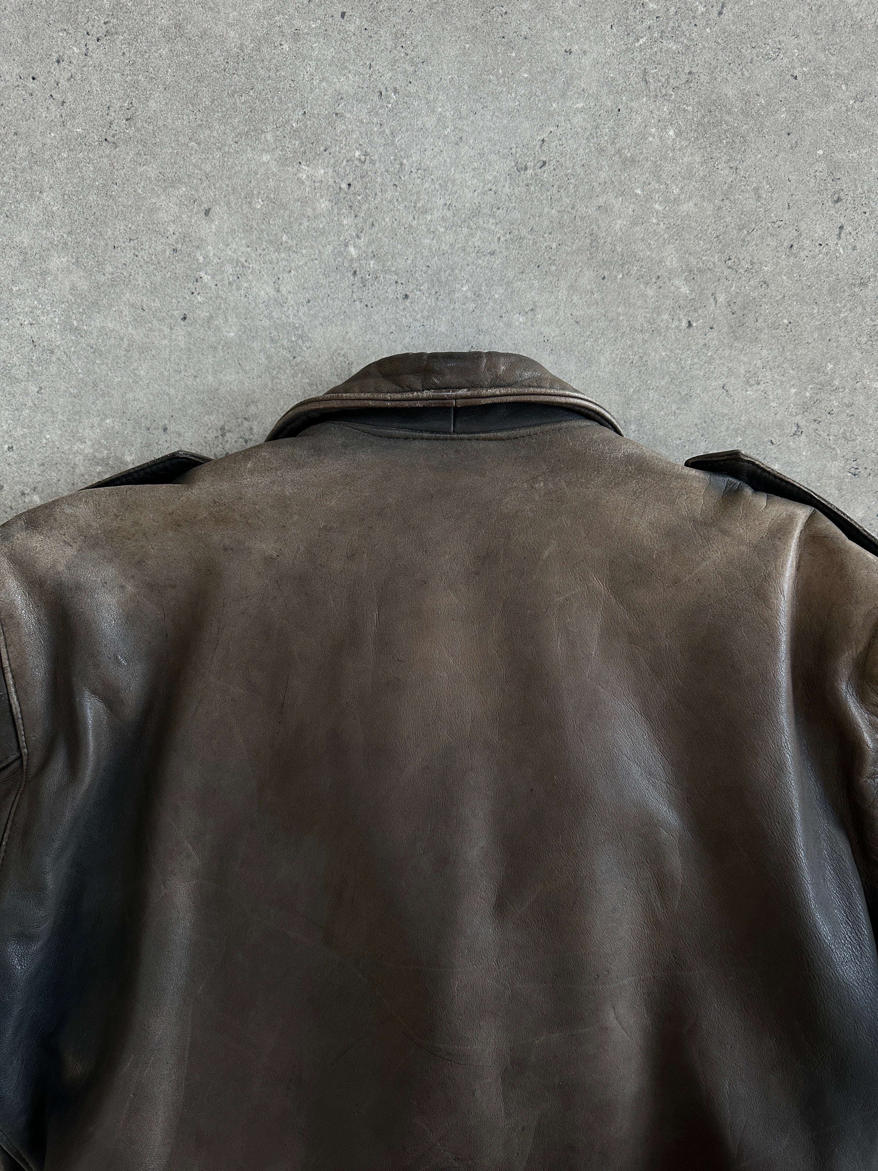 Vintage 1980s distressed leather biker jacket, small size, featuring rugged texture and classic motorcycle style.