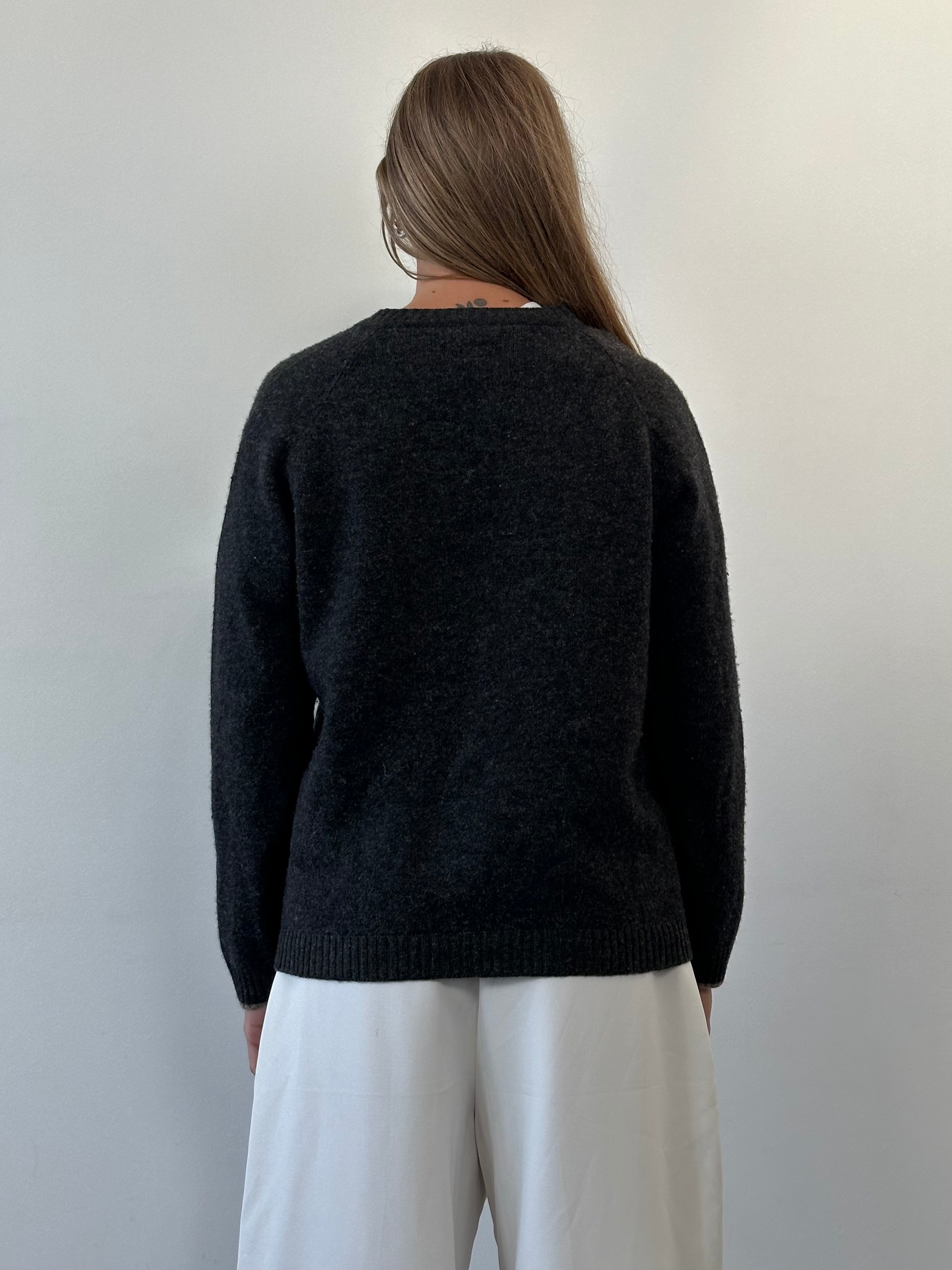 Armani Jeans wool V-neck jumper in size M/L, featuring a classic fit and soft knit fabric, displayed on a neutral background.
