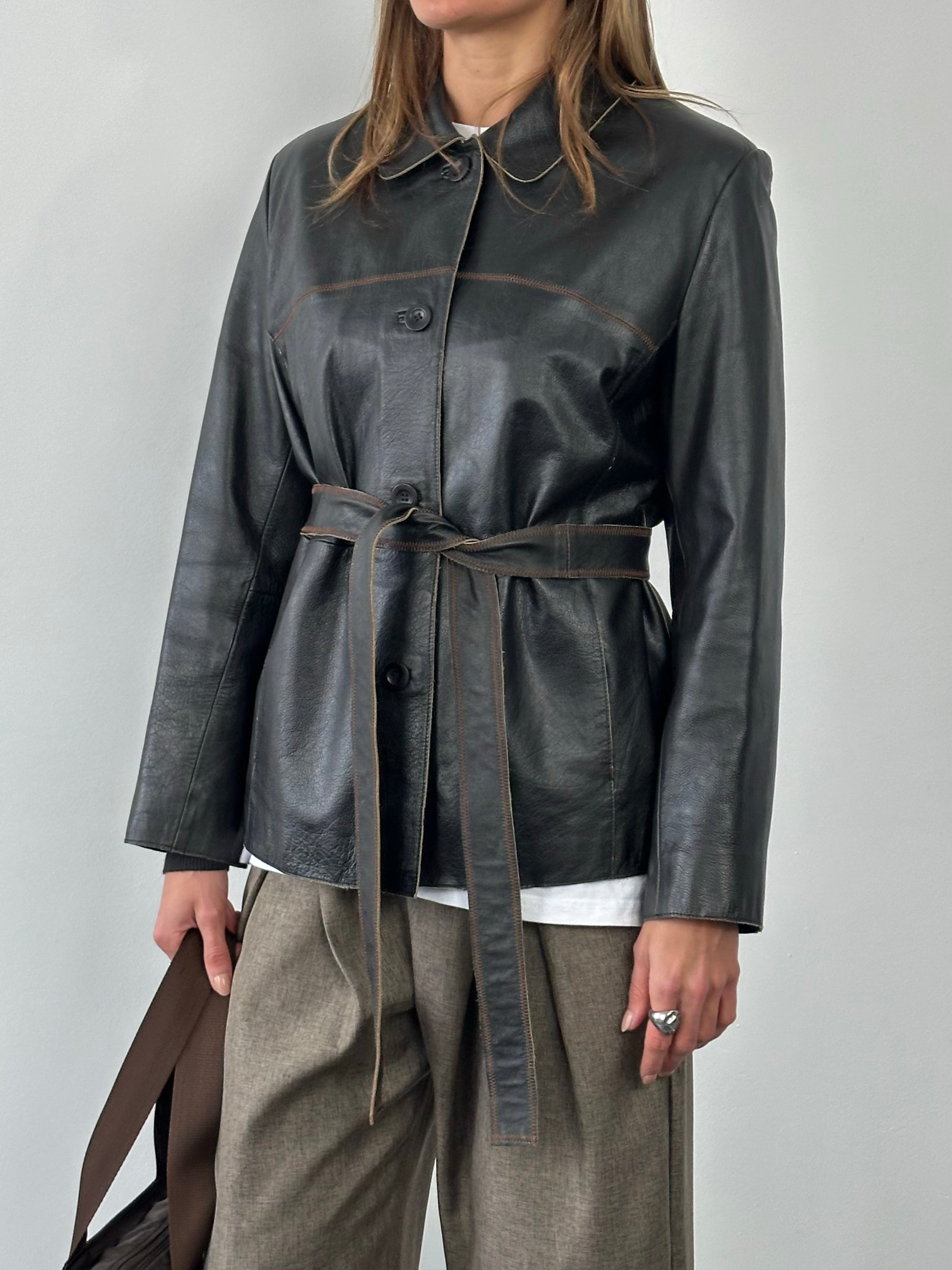 Vintage 1990s leather belted jacket in black leather, featuring a classic fit and detailed stitching, styled for a retro look.