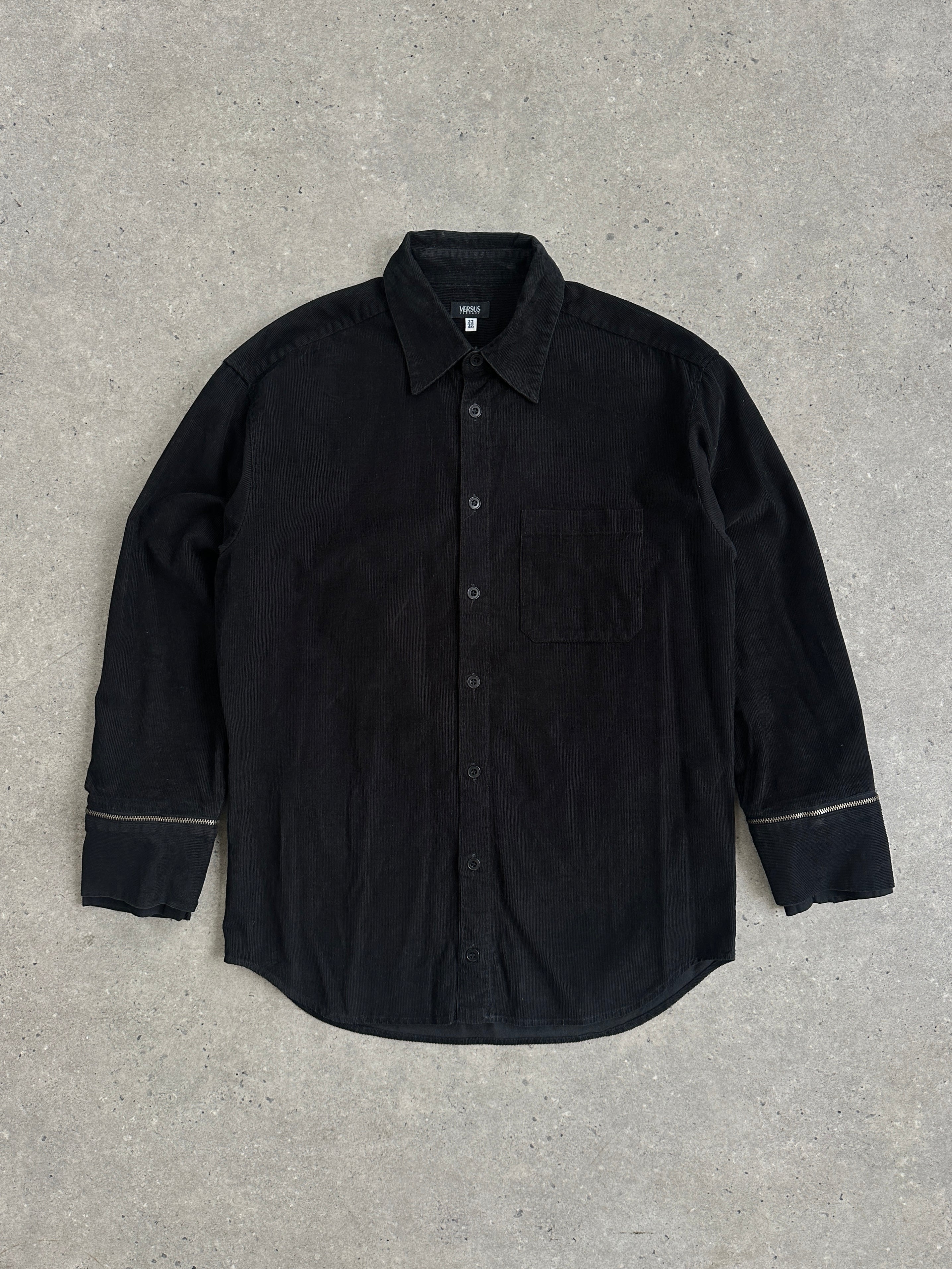 Versace Versus 00s corduroy zip shirt in black, featuring a stand collar and front zipper, on a plain background.