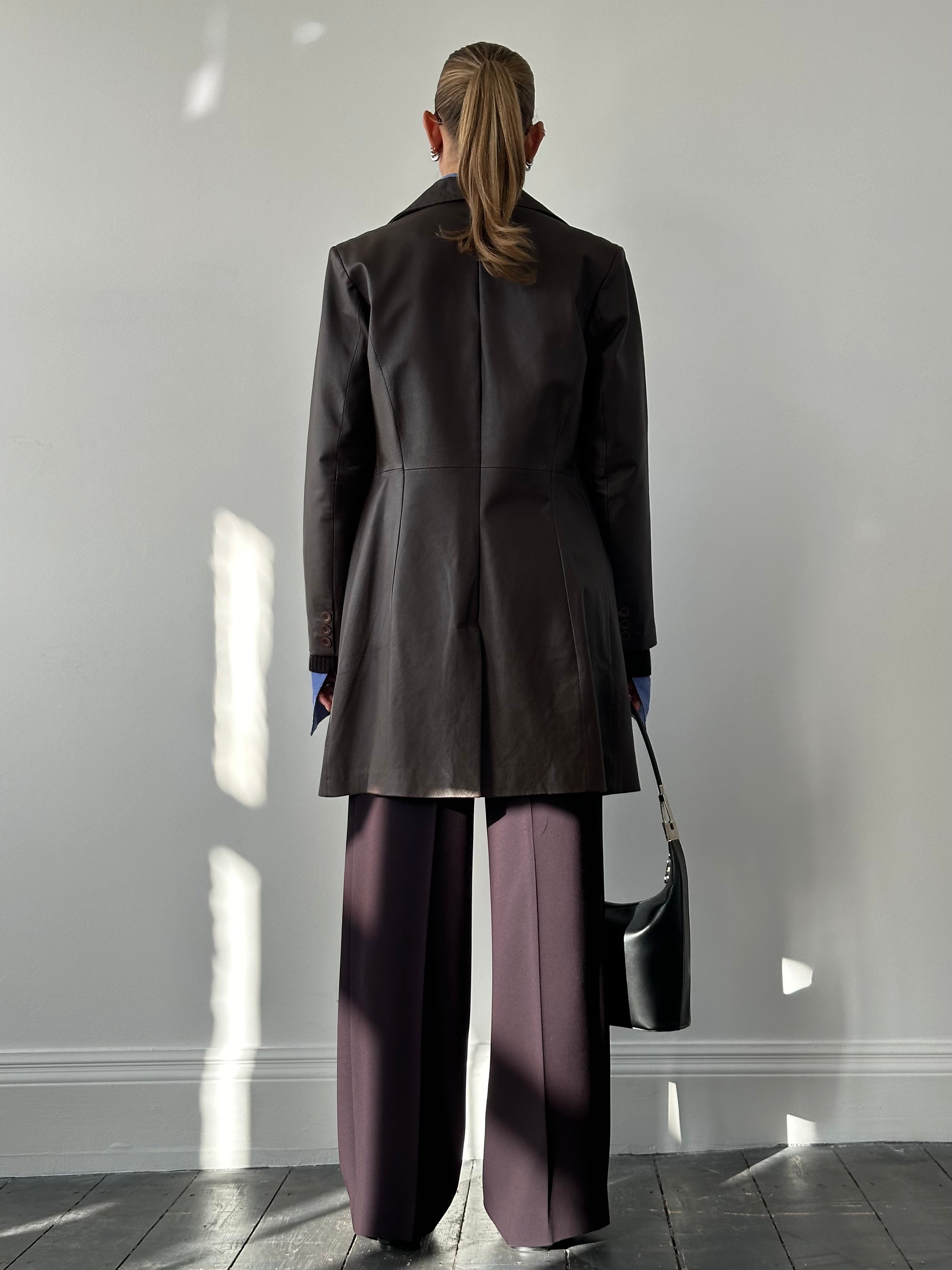 Vintage leather trench coat jacket in medium/large size, featuring classic design and distressed leather texture.