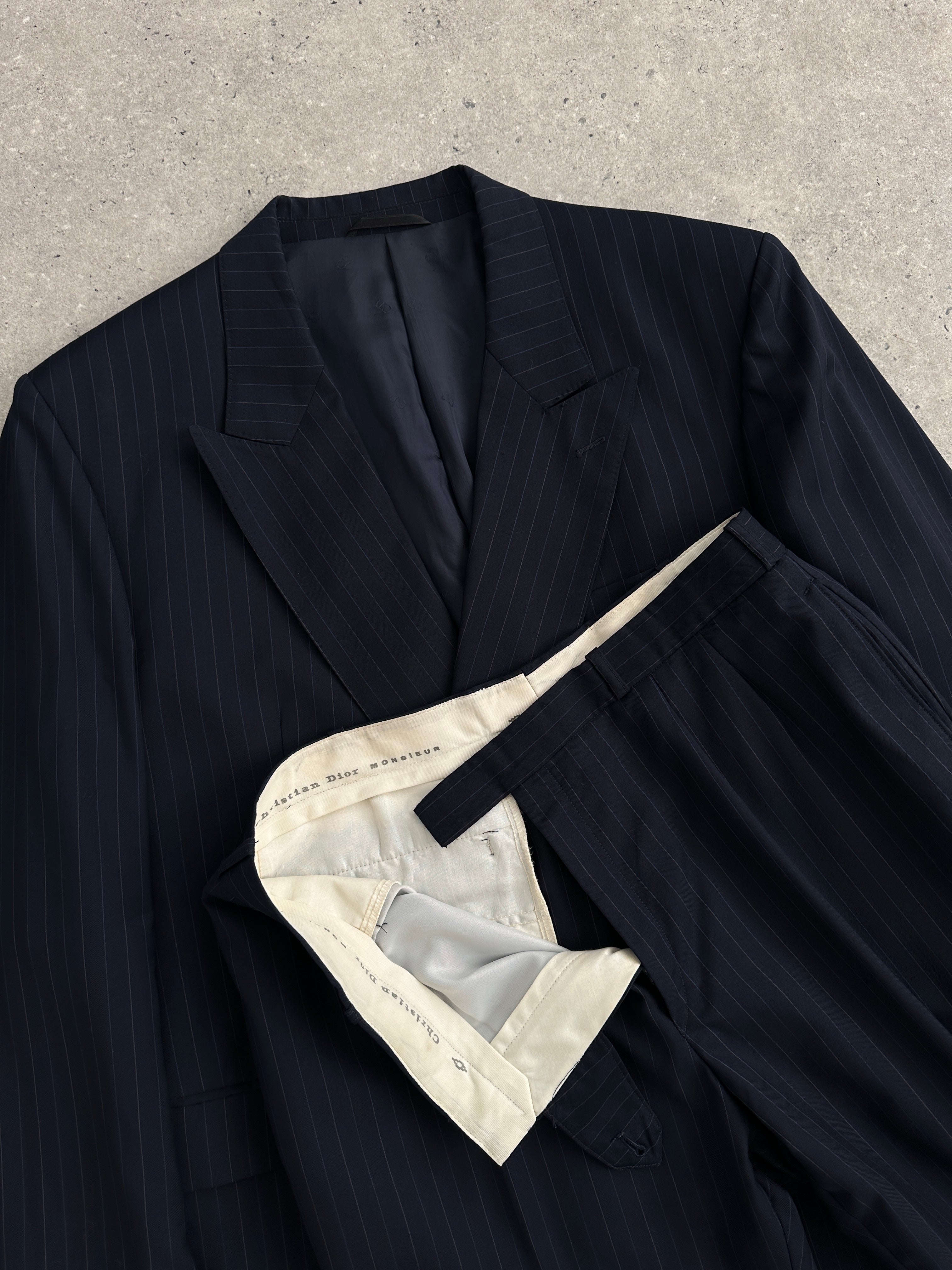 Christian Dior Monsieur pinstripe wool double-breasted suit, 44S/W34, displayed on a hanger with detailed fabric texture.