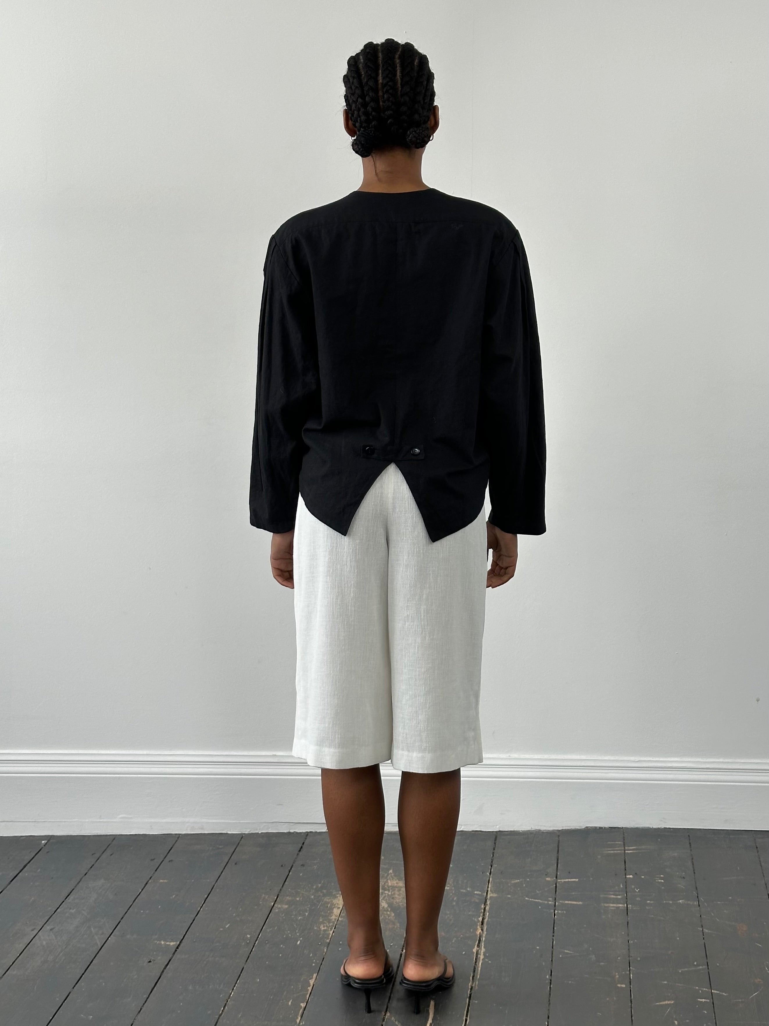 Vintage Japanese 1990s high-waisted pleated culottes shorts in beige, showcasing retro style and wide-leg fit.