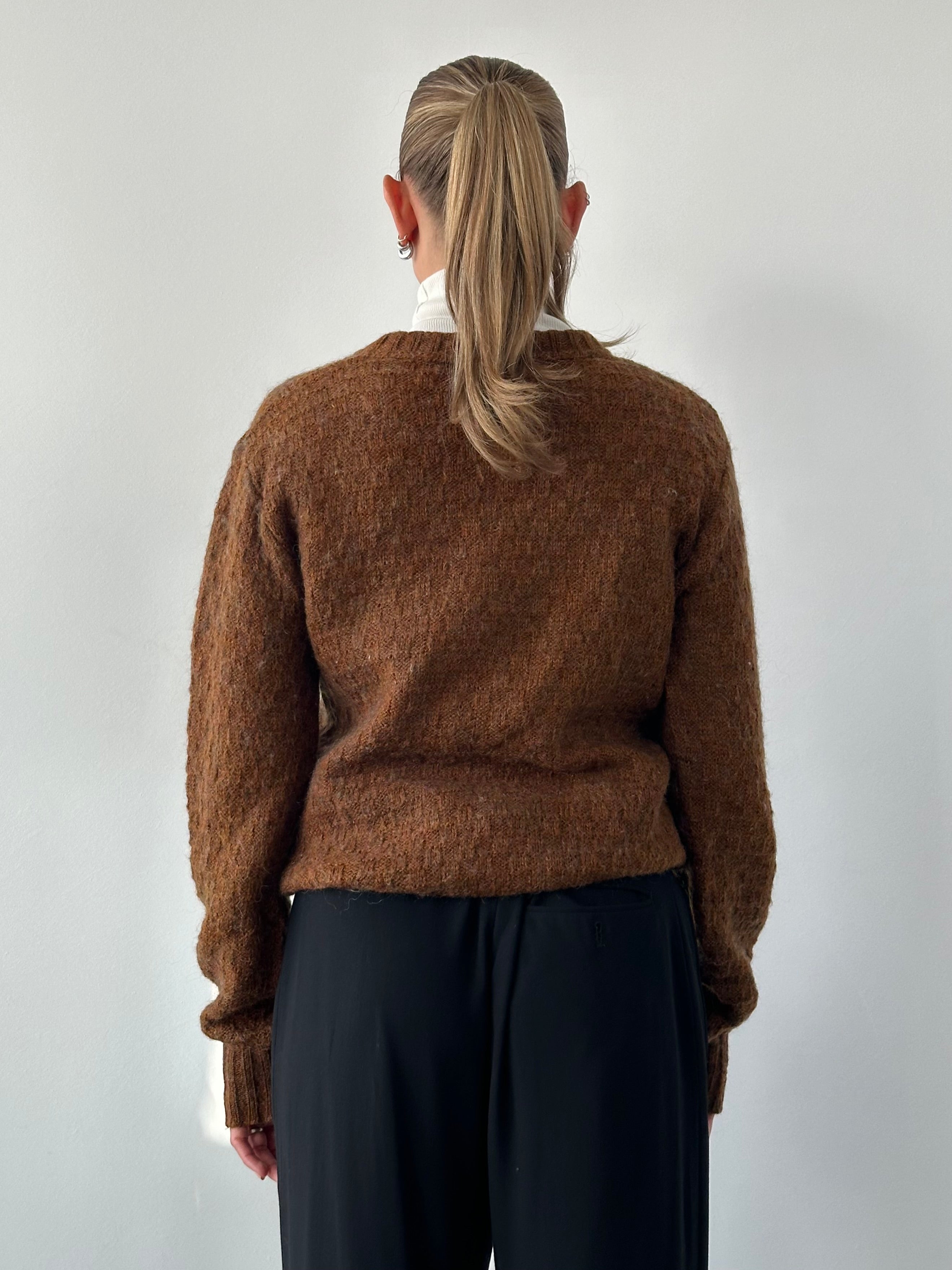 Vintage Italian wool V-neck knitted jumper in size M, featuring a cozy, classic design with a textured knit pattern.
