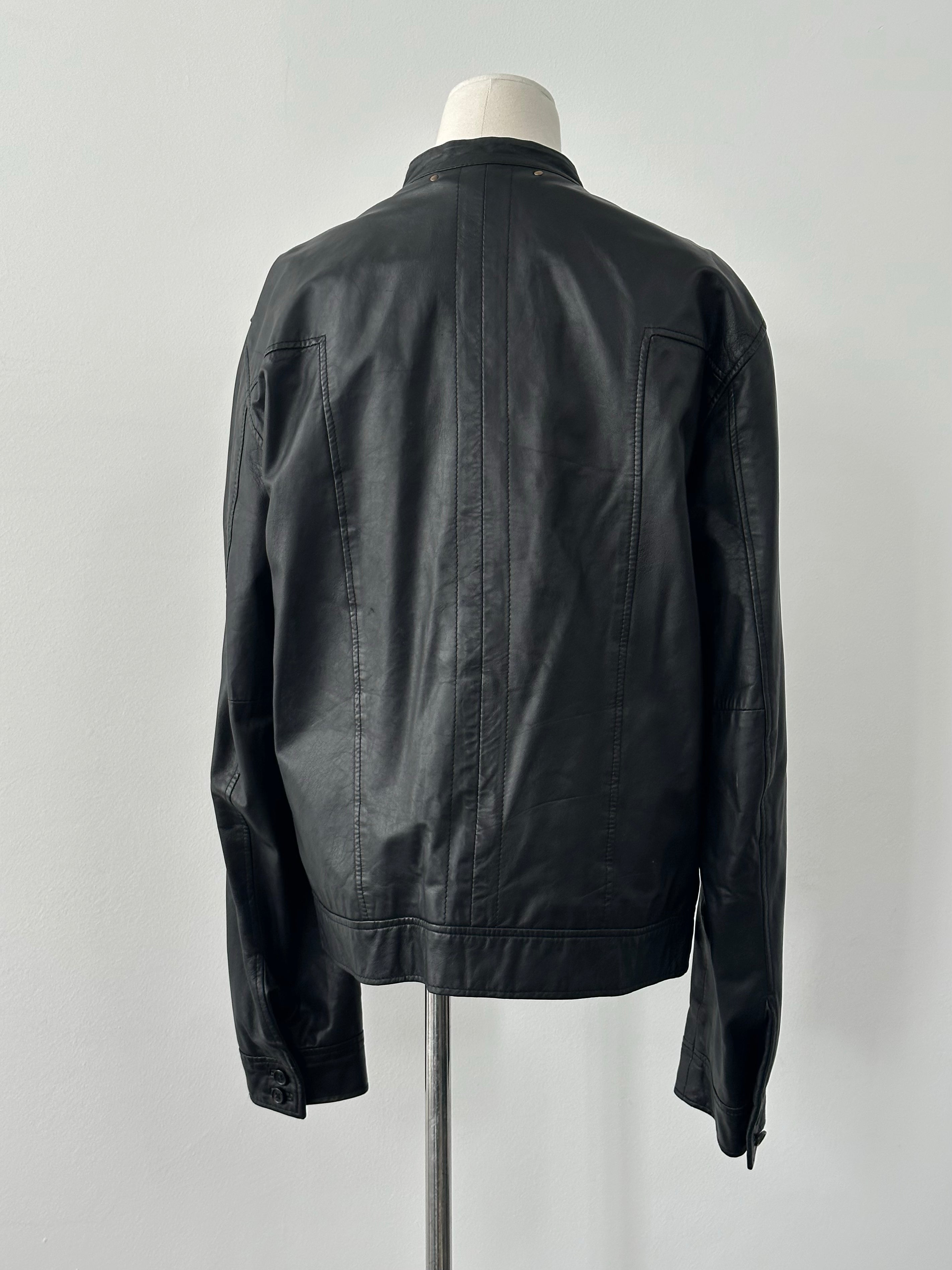 Vintage 1990s double-breasted leather jacket in brown, with wide lapels and button details, displayed on a hanger.