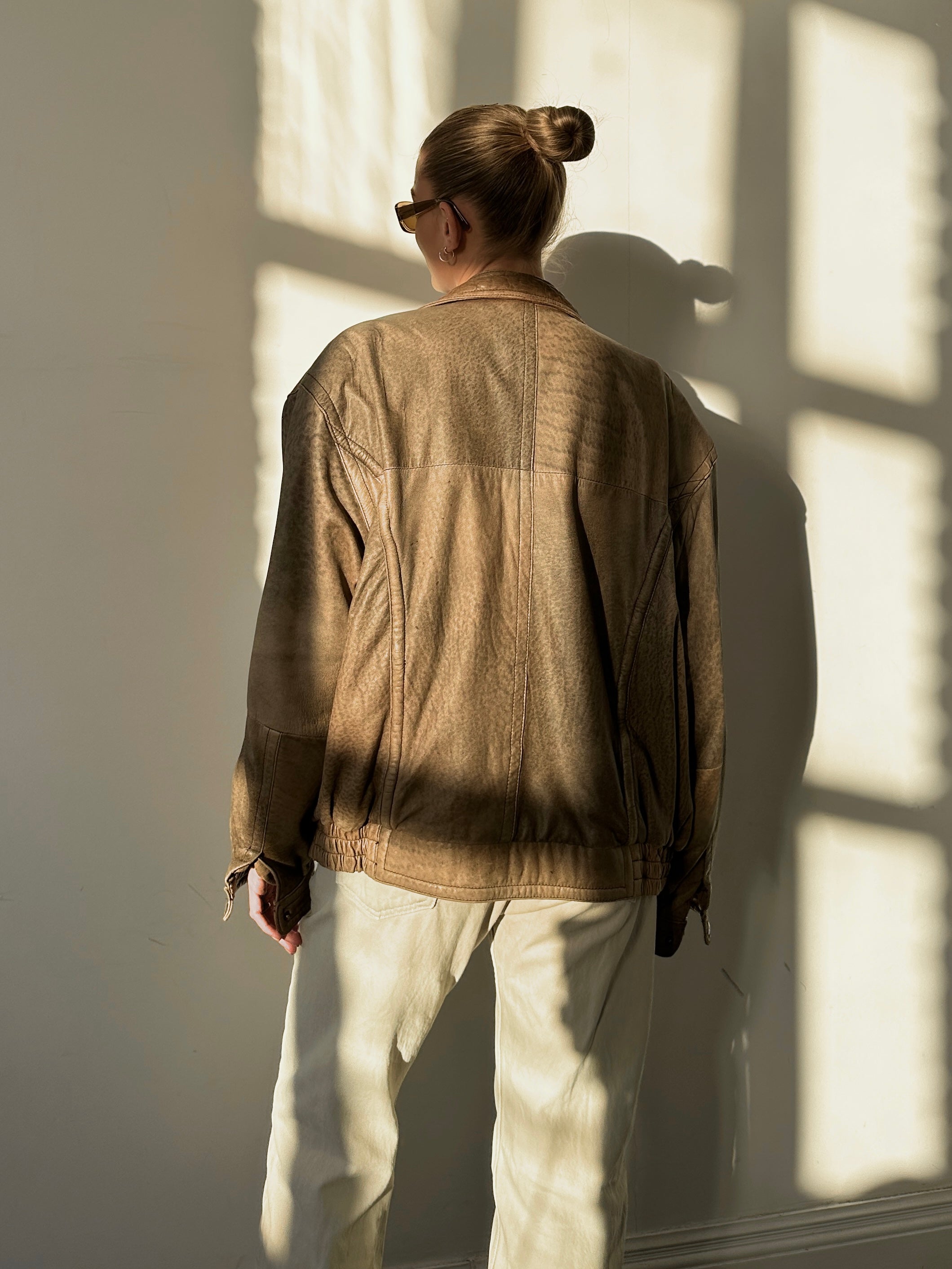 Vintage leather bomber jacket in size L/XL, featuring classic design with ribbed collar and cuffs, durable and stylish for men.