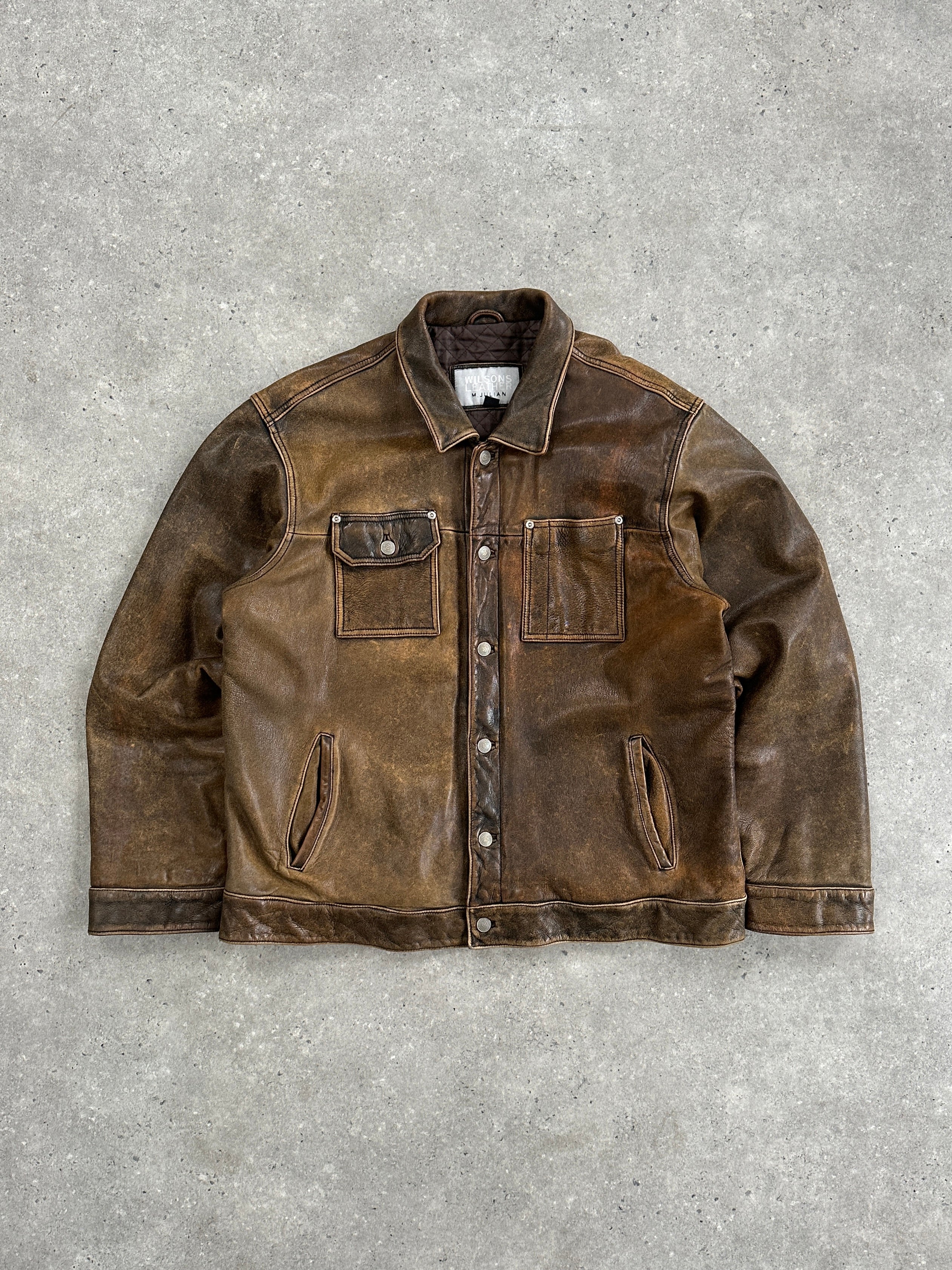 Vintage aged leather trucker jacket in XL, showcasing rugged texture and classic style with detailed stitching and worn finish.