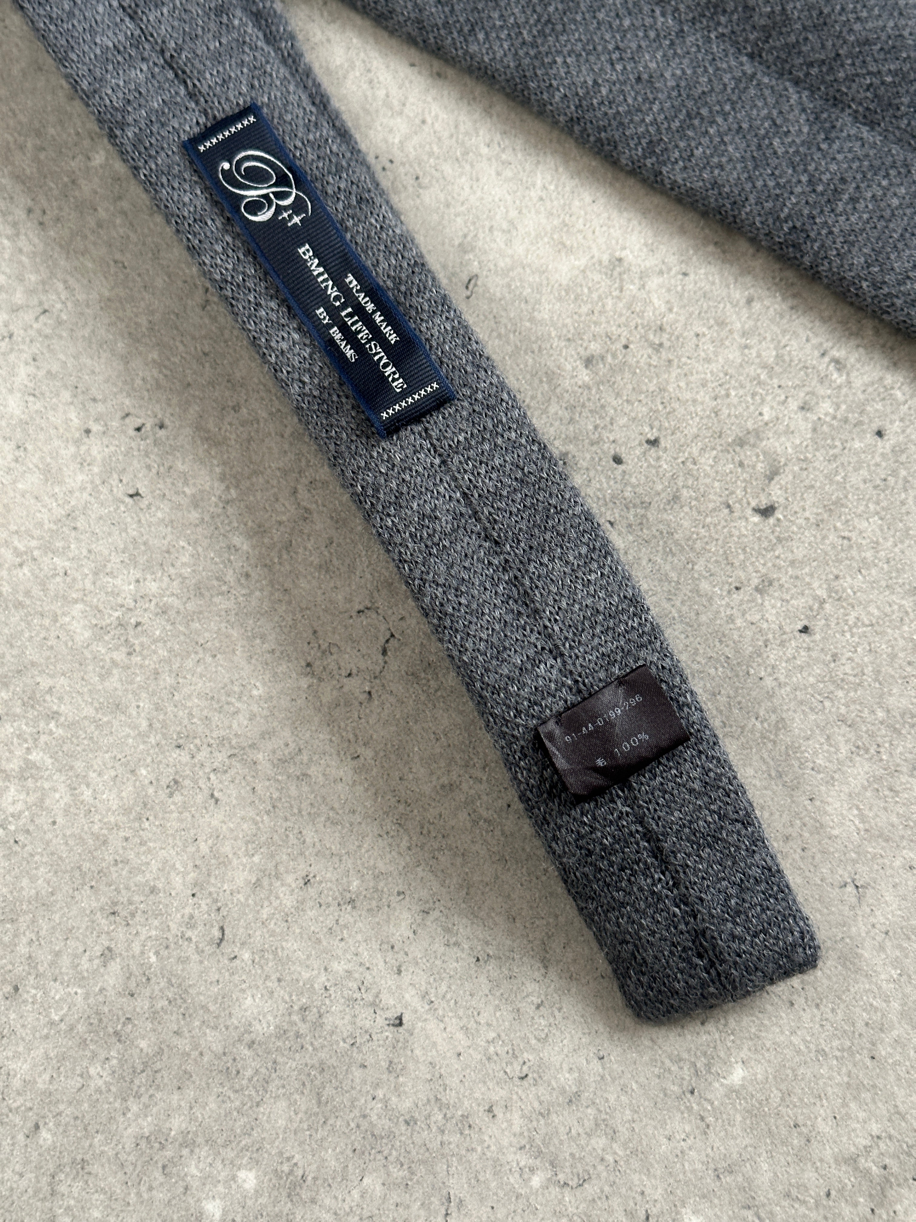 Vintage Japanese 1990s pure wool knitted flag tie showing colorful woven flag pattern and classic tie shape.