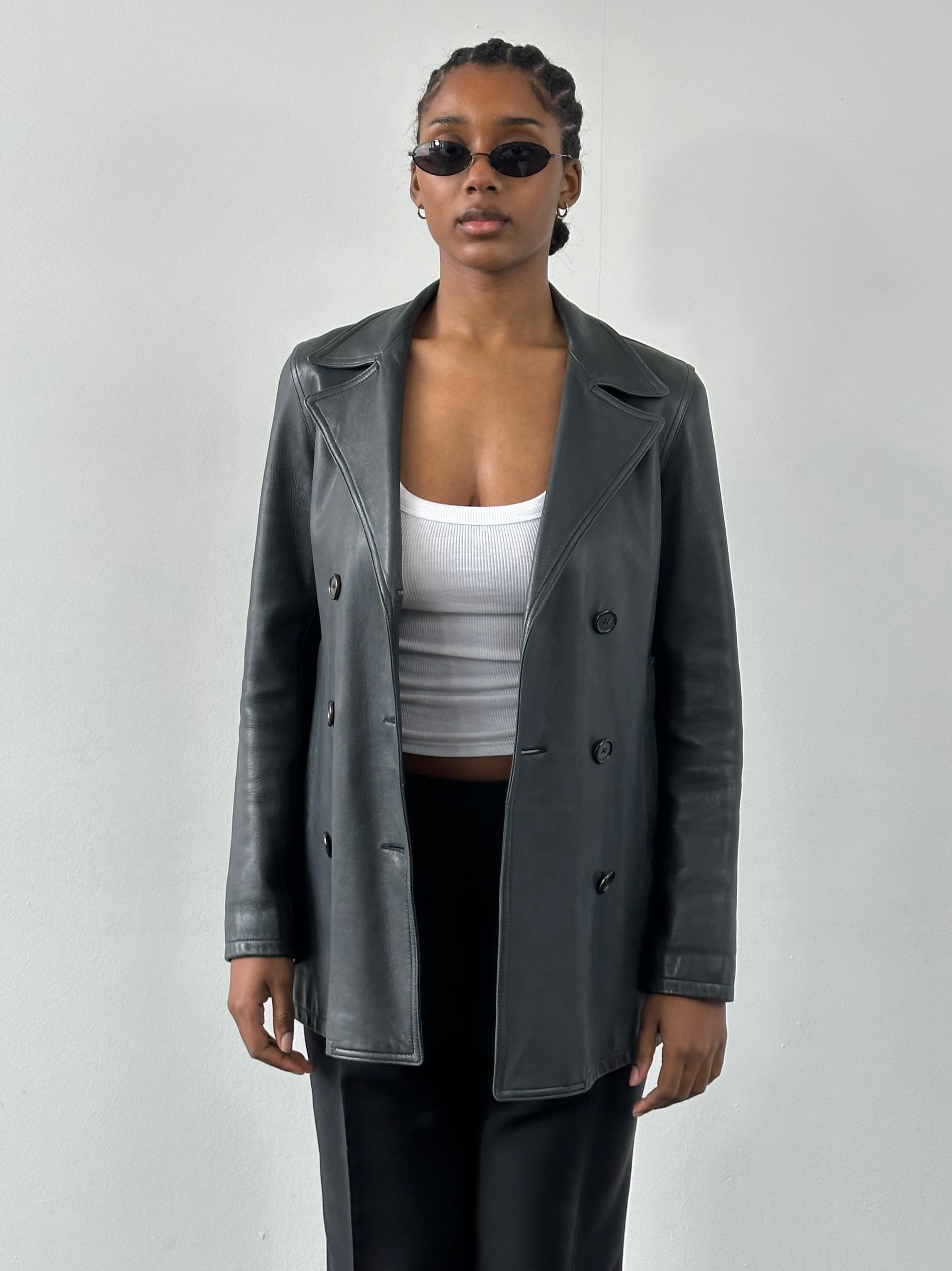 Jaeger 2000s double-breasted leather jacket in black, featuring classic lapels and button details, worn by a person.