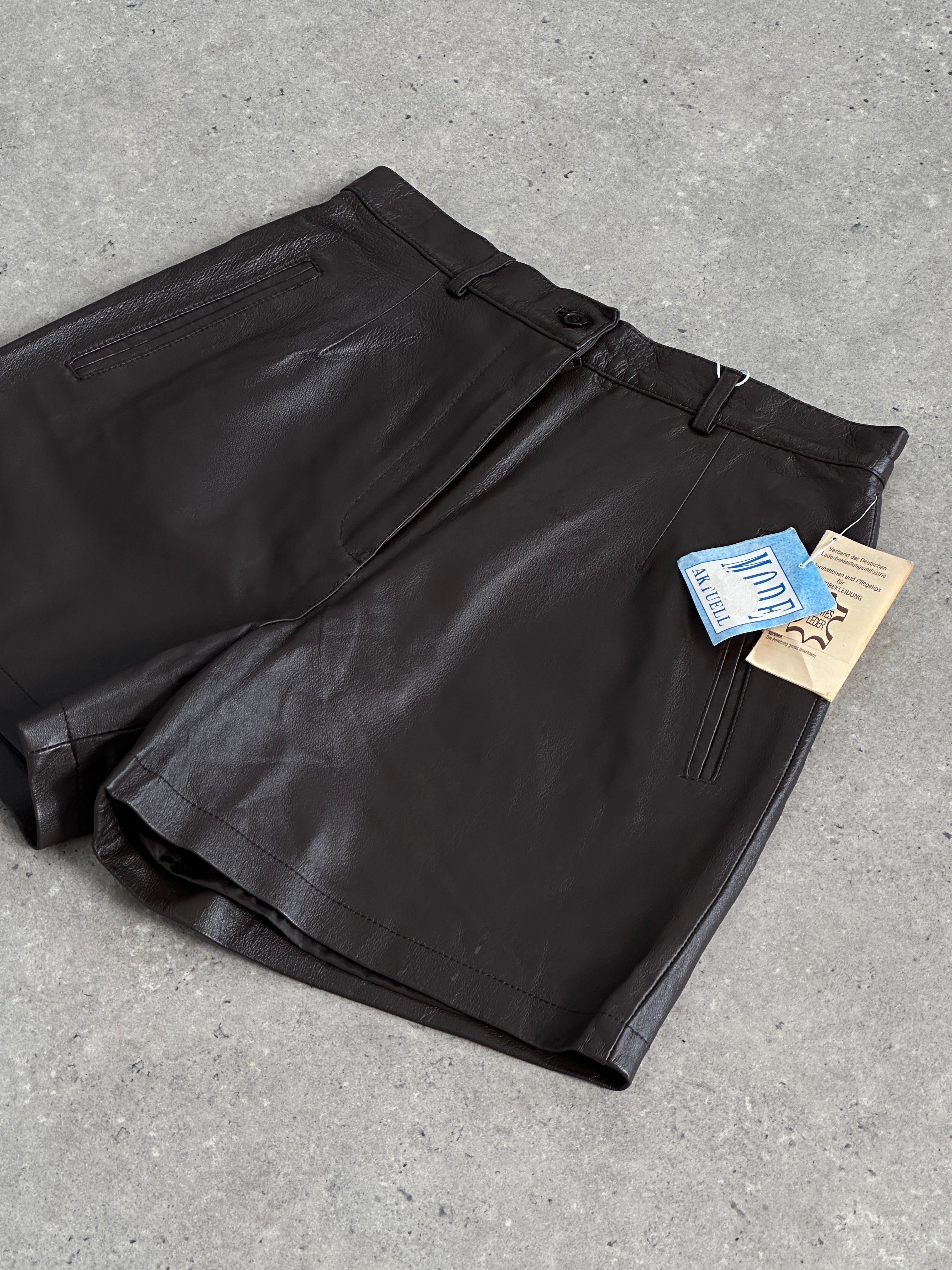 Vintage 2000s leather high-waisted mini shorts in black, featuring a fitted waist and classic short length.