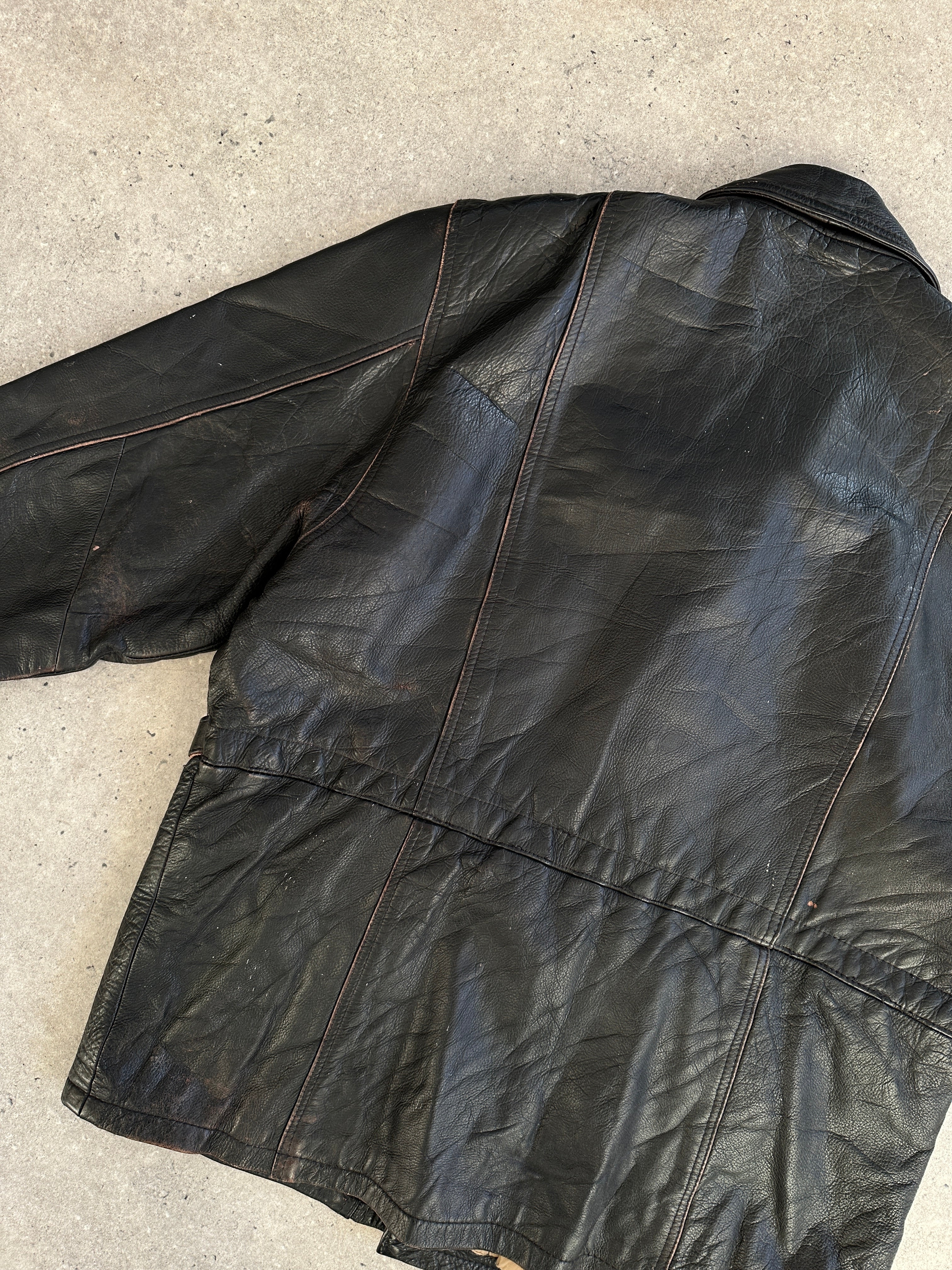 Vintage distressed leather jacket in XL size, featuring rugged texture and classic style, shown on a hanger.