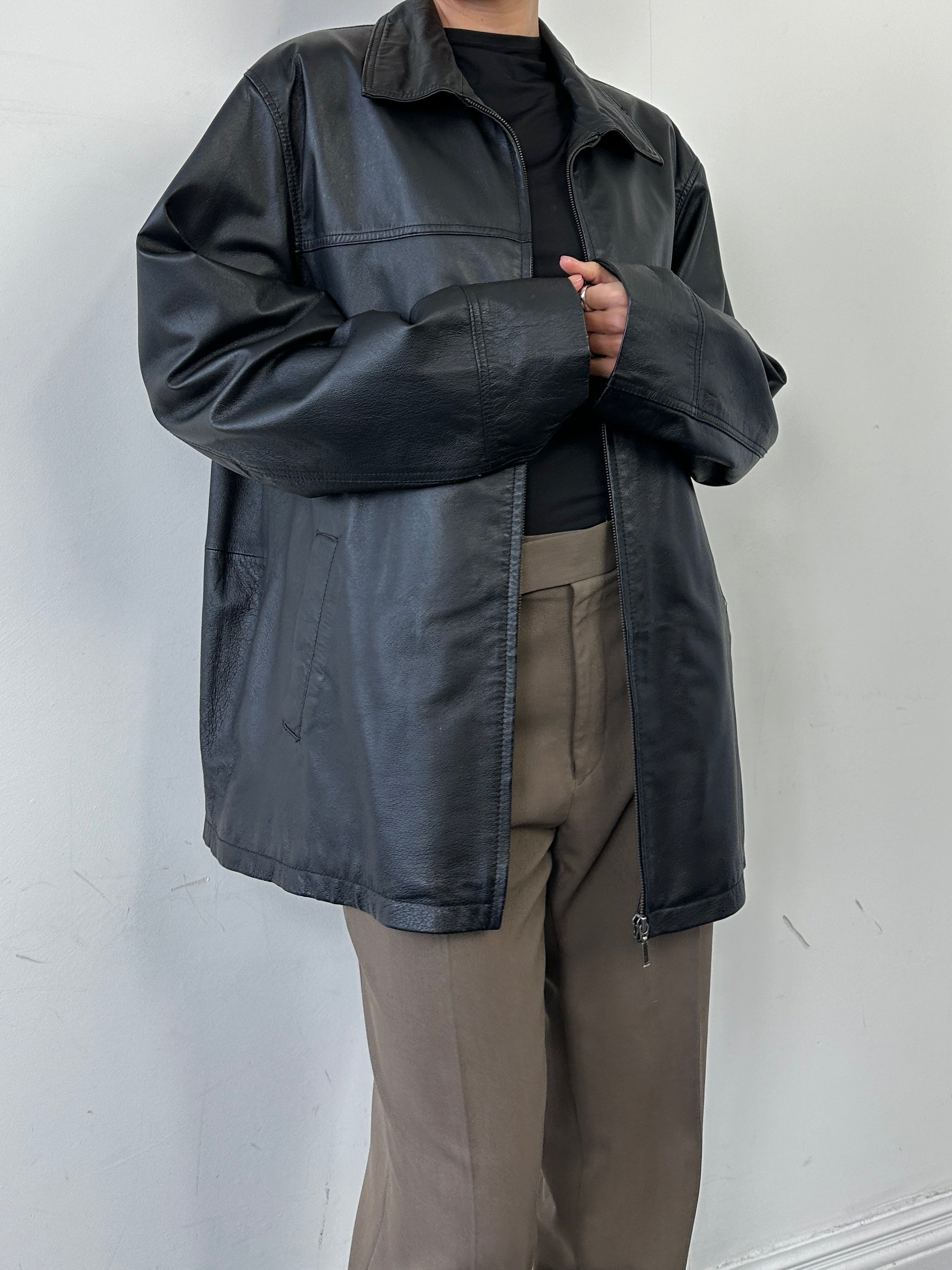 Vintage minimal leather jacket in XL size featuring a classic design and smooth leather texture, displayed on a hanger.