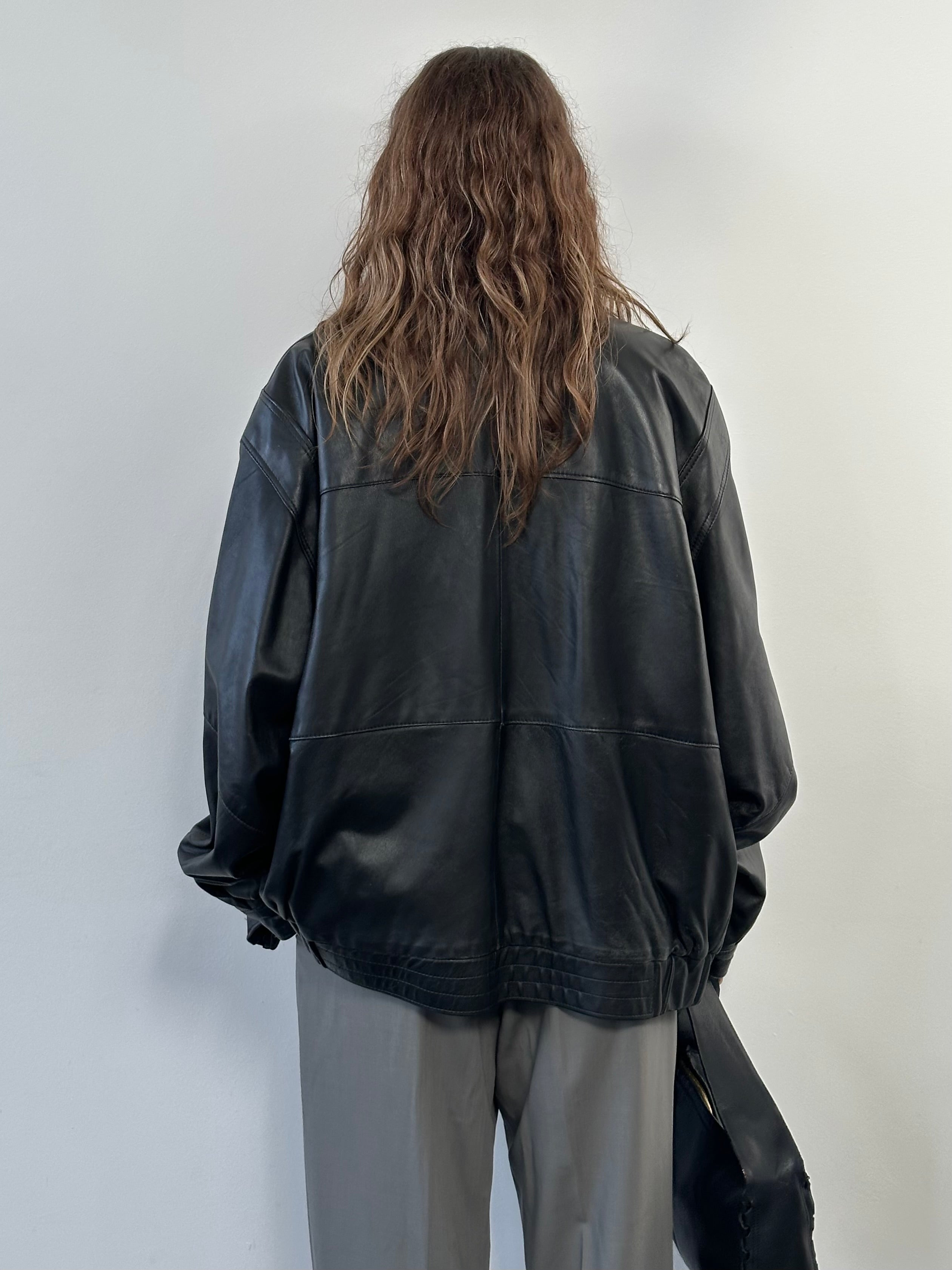 Vintage 1990s leather bomber jacket in XL size, classic style with a worn leather finish and ribbed collar.