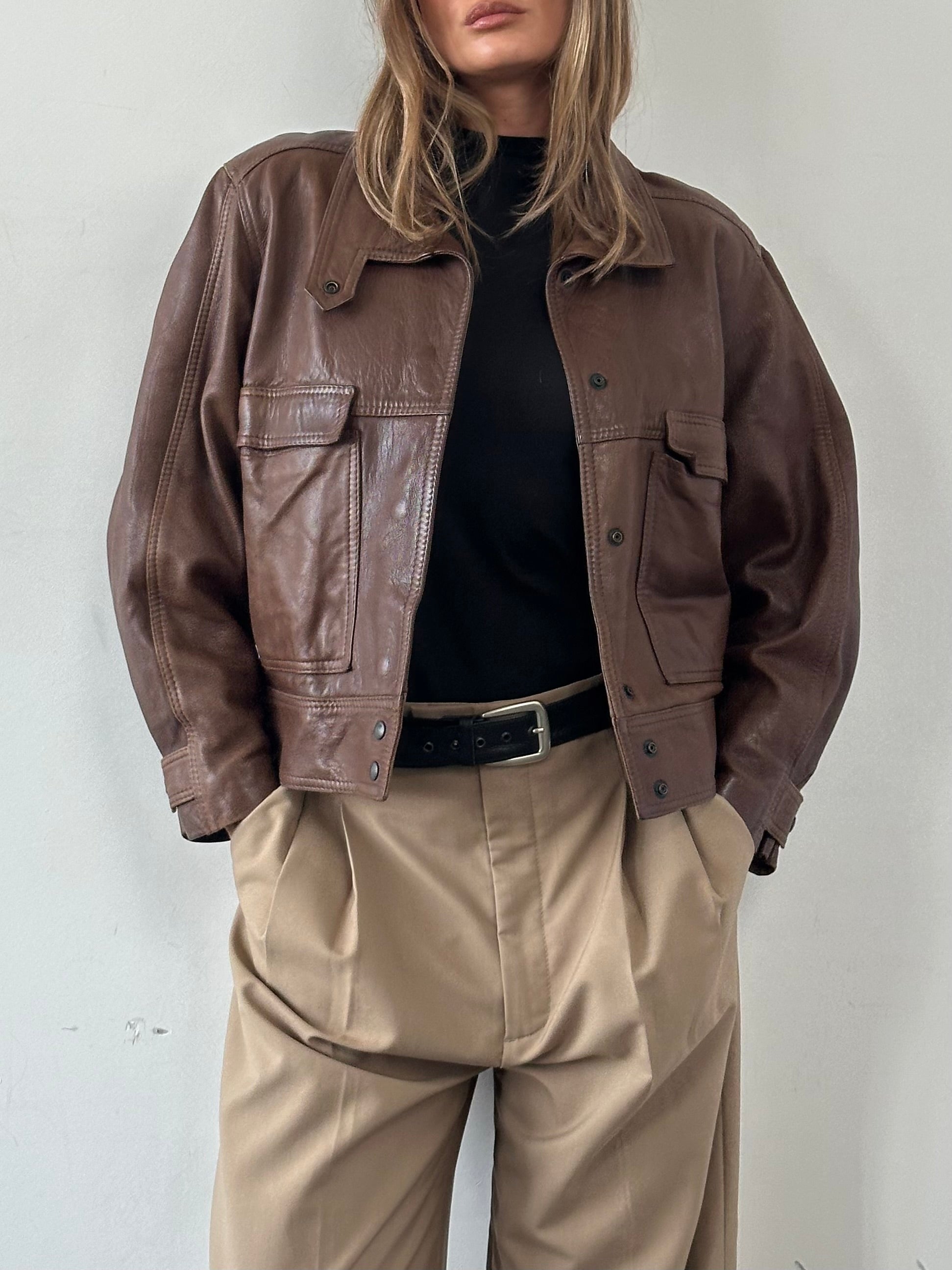 Vintage cropped leather jacket in black, stylish S/M fit with classic design and textured leather exterior.