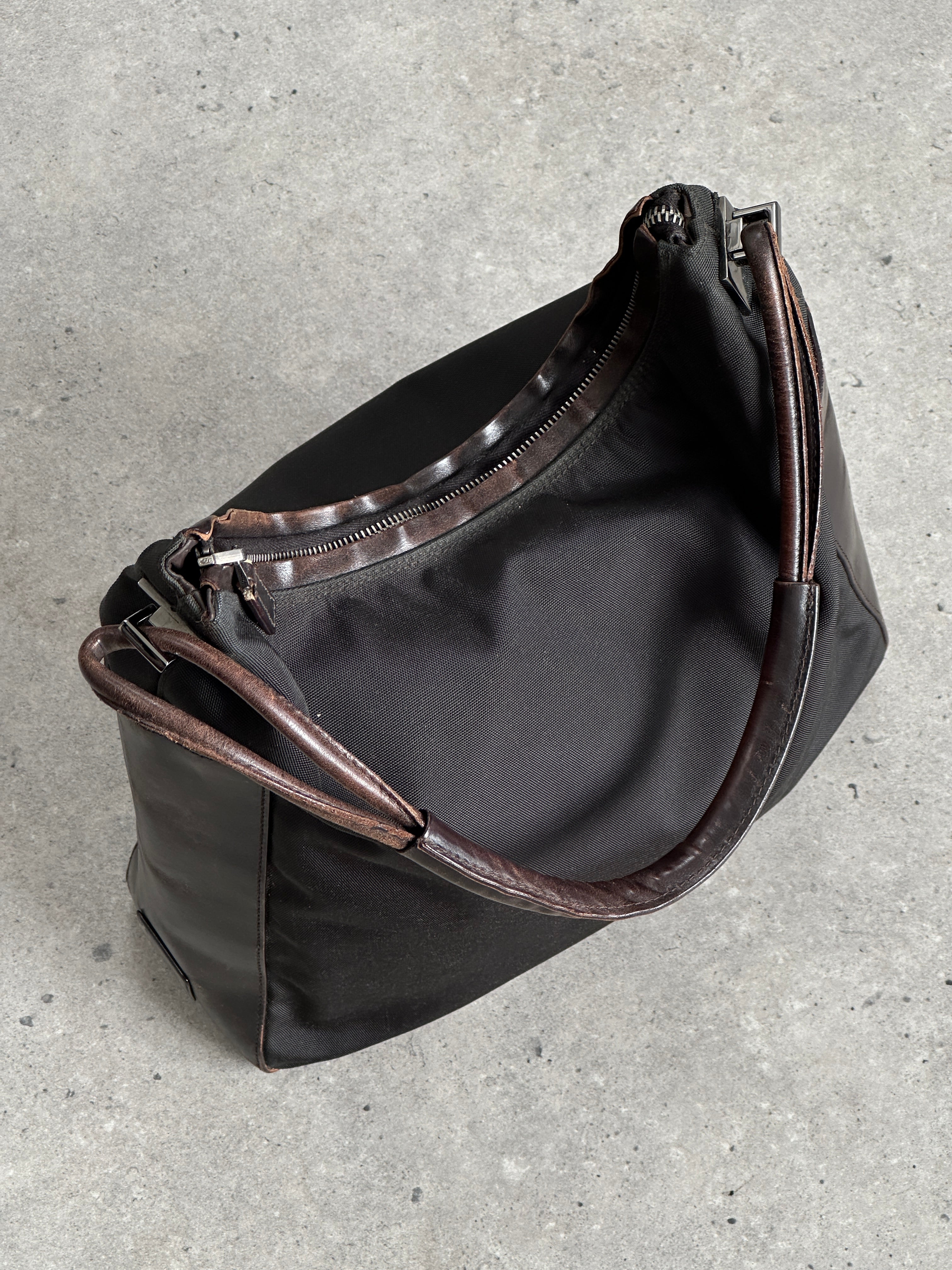 Gucci canvas leather shoulder bag with adjustable strap and classic logo design, stylish and spacious for everyday use.