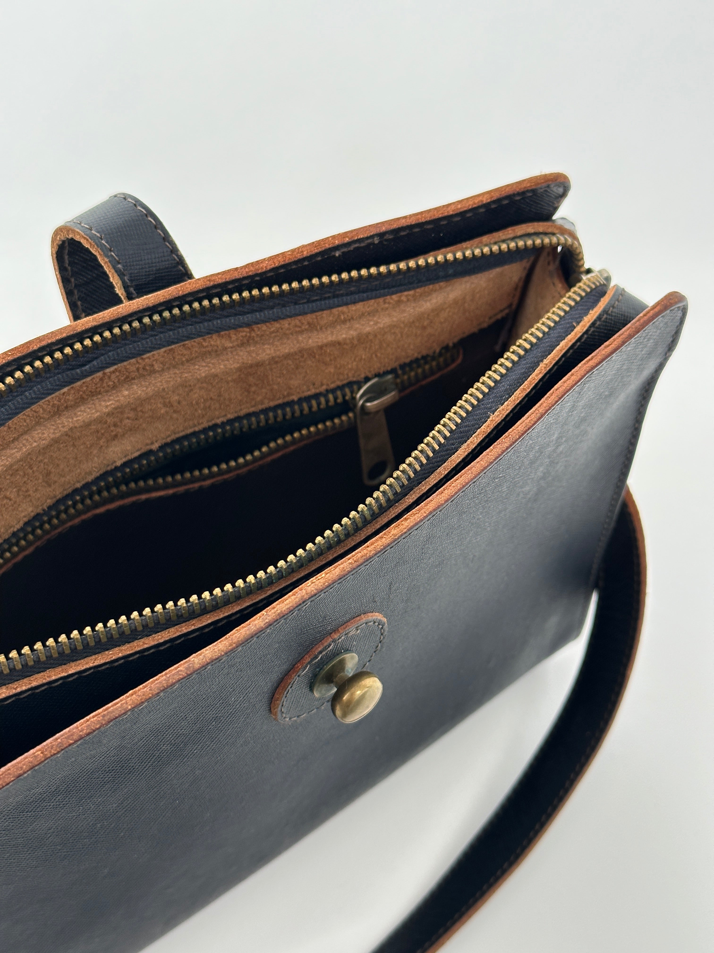 Vintage leather crossbody bag with adjustable strap and classic design, perfect for stylish everyday use.