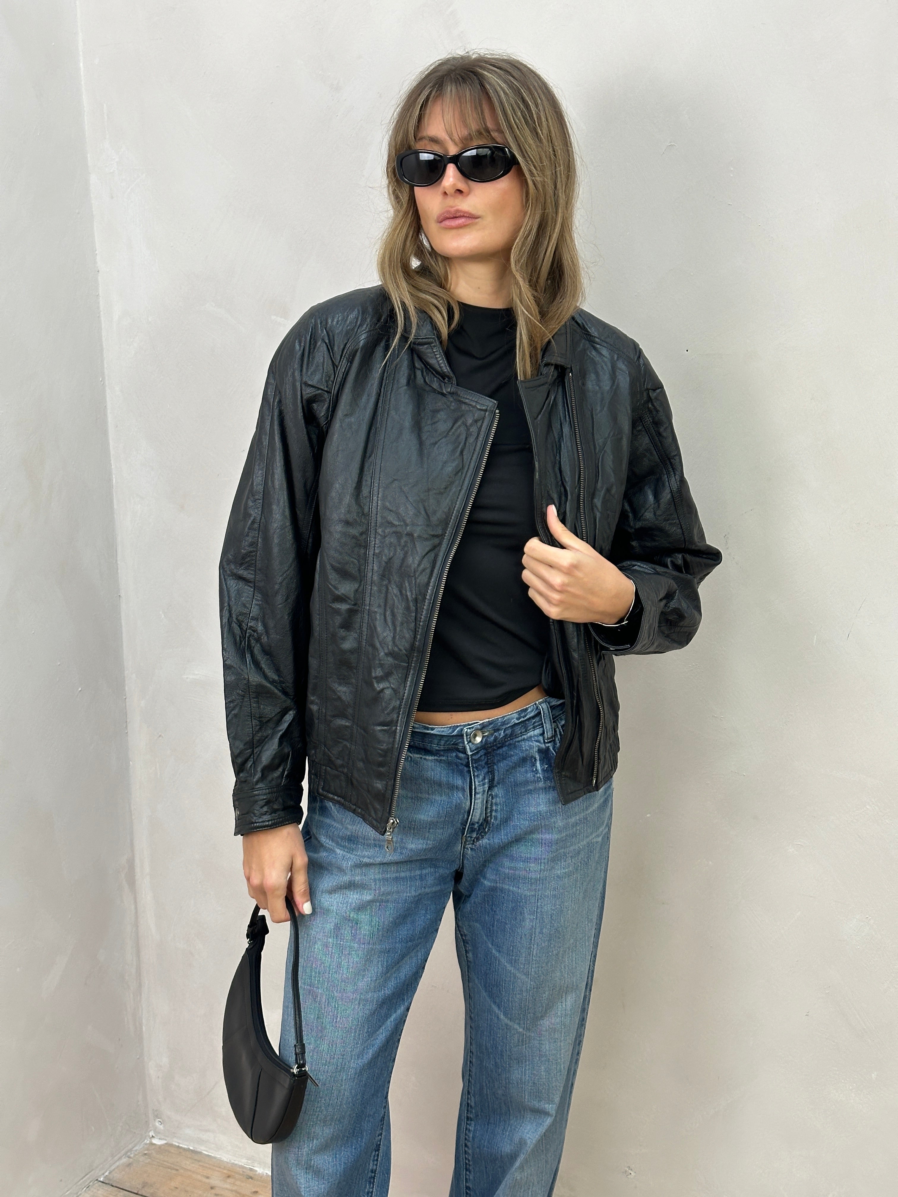 Vintage leather biker jacket in size S/M, featuring classic design, rugged texture, and detailed stitching.