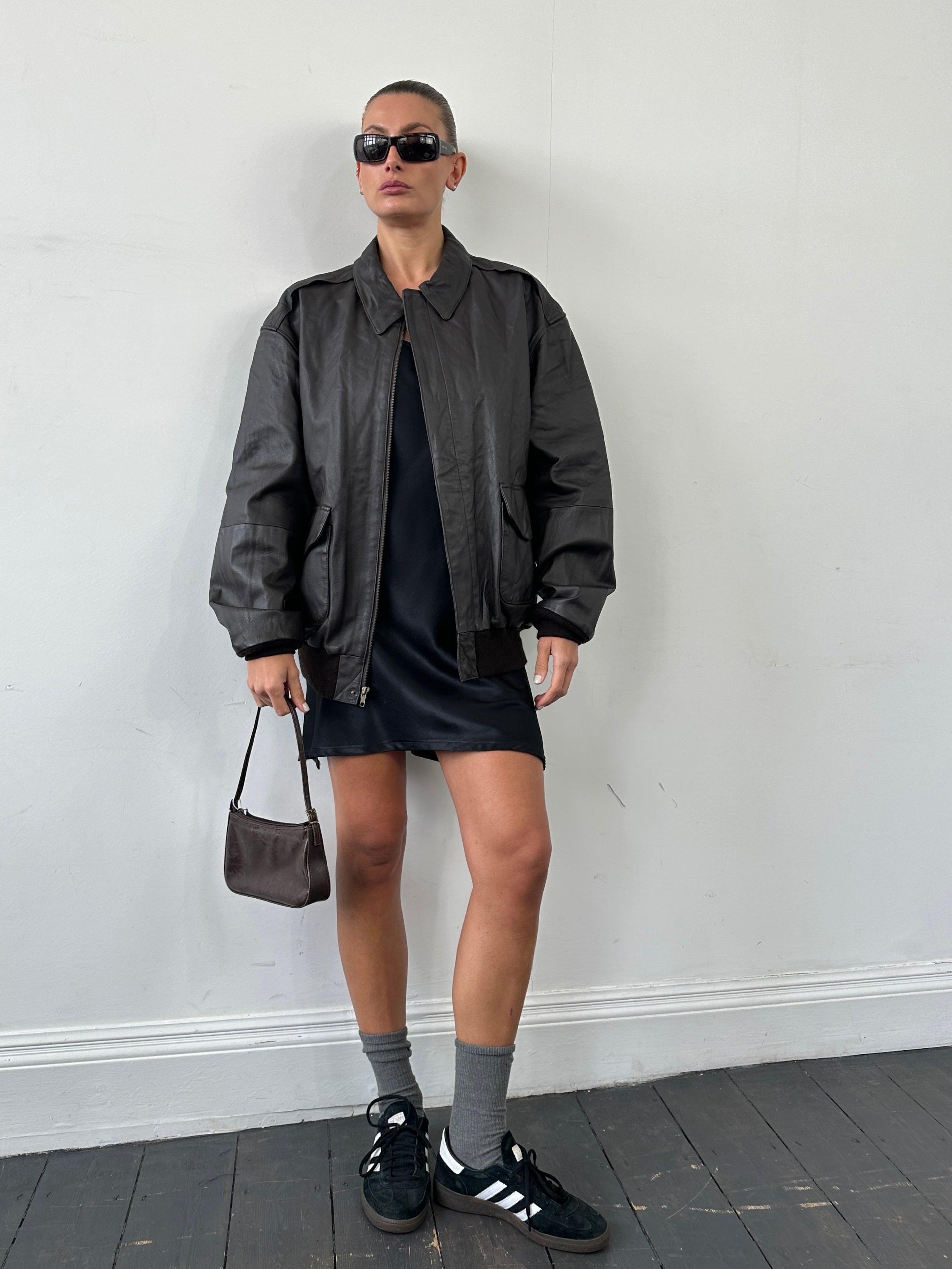 Vintage leather bomber jacket in XL size, featuring classic design with a worn leather finish and ribbed collar and cuffs.