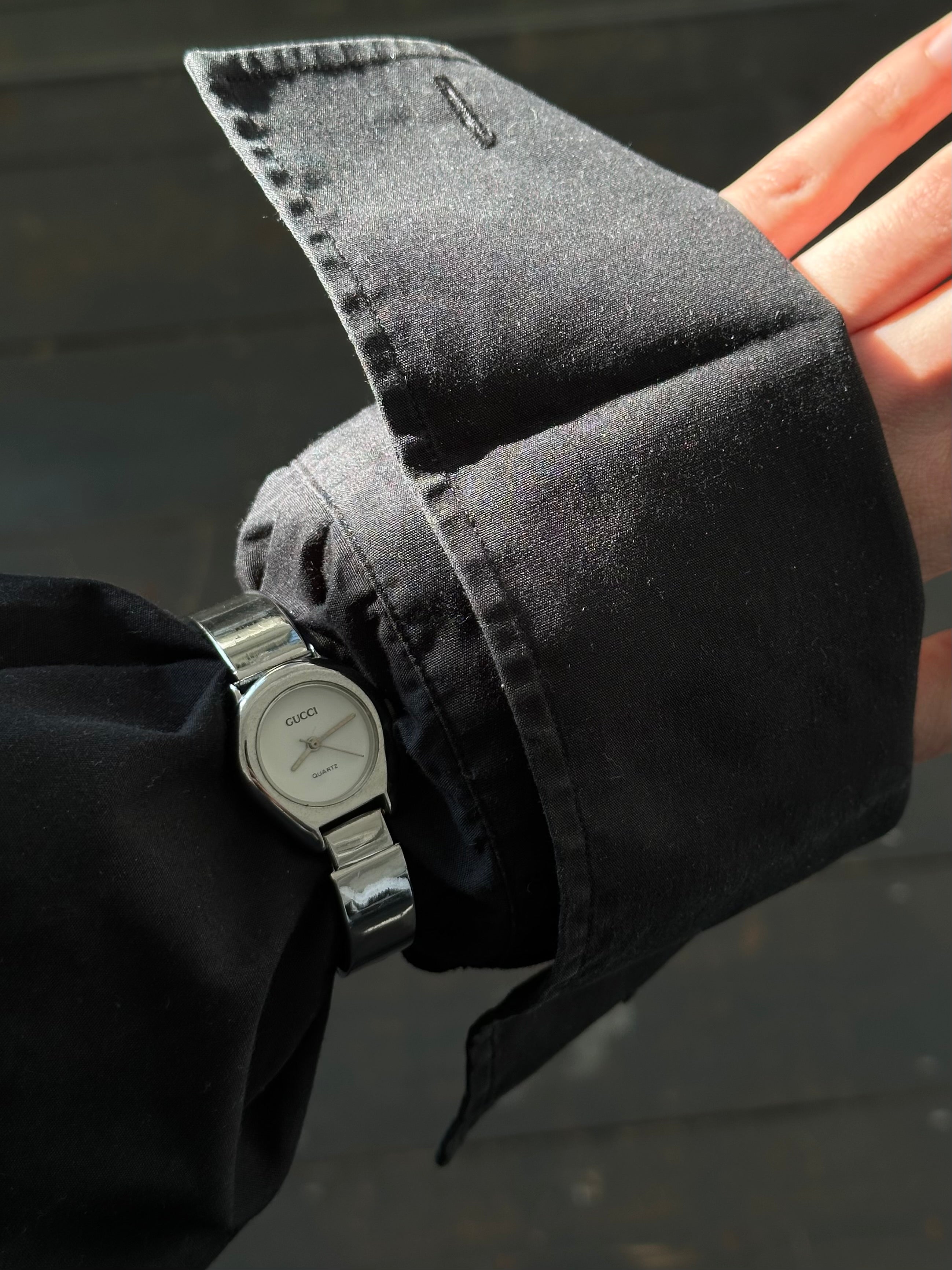 Gucci 1990s stainless steel quartz watch with a sleek round face and classic design, showcasing the luxury brand's timeless style.