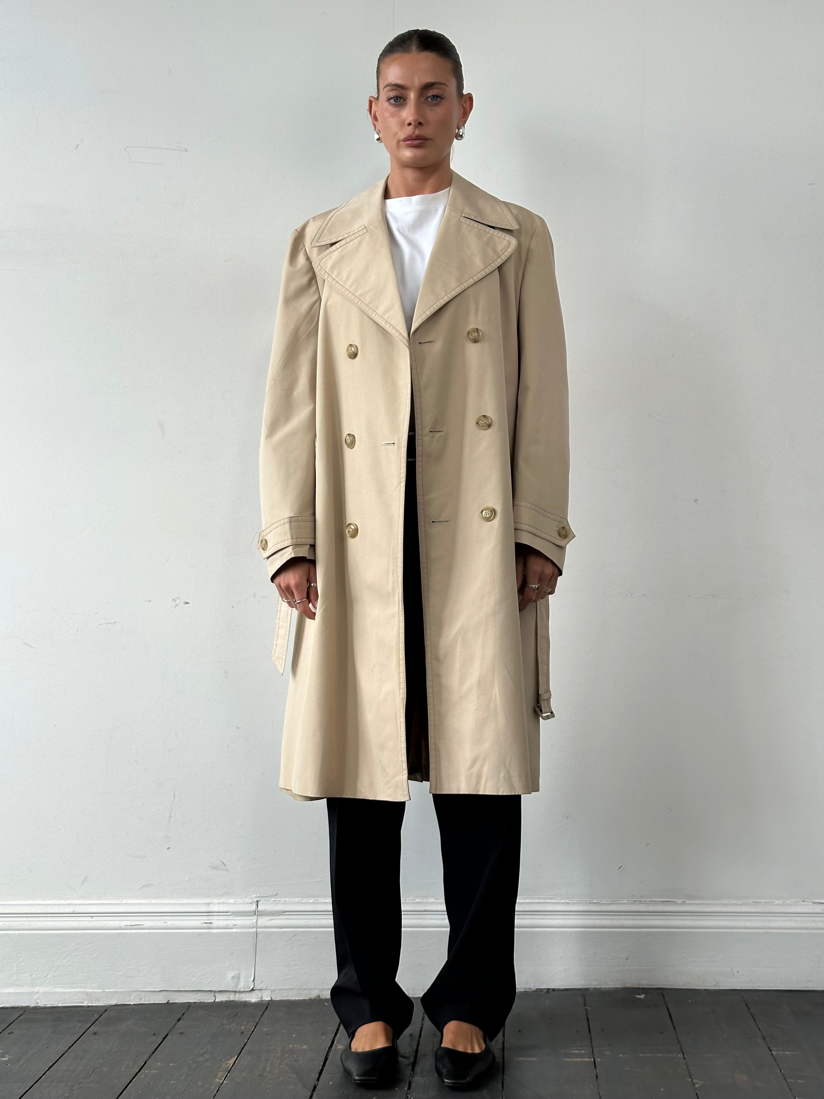 Vintage double-breasted belted trench coat in classic style, shown in size M/L with leather belt and timeless design.