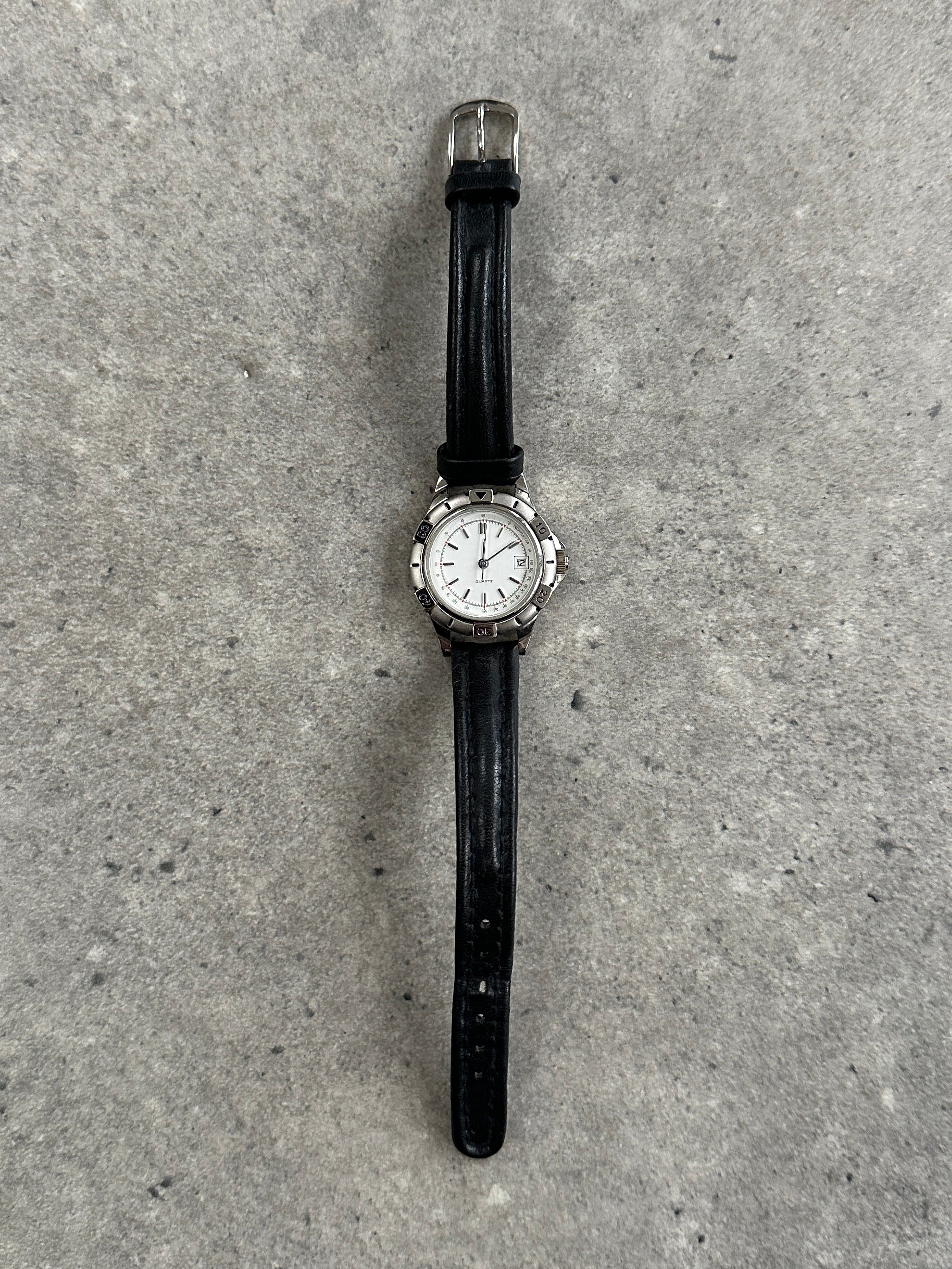 Vintage 1990s silver tone quartz watch with round face and Japan movement, featuring a classic vintage design