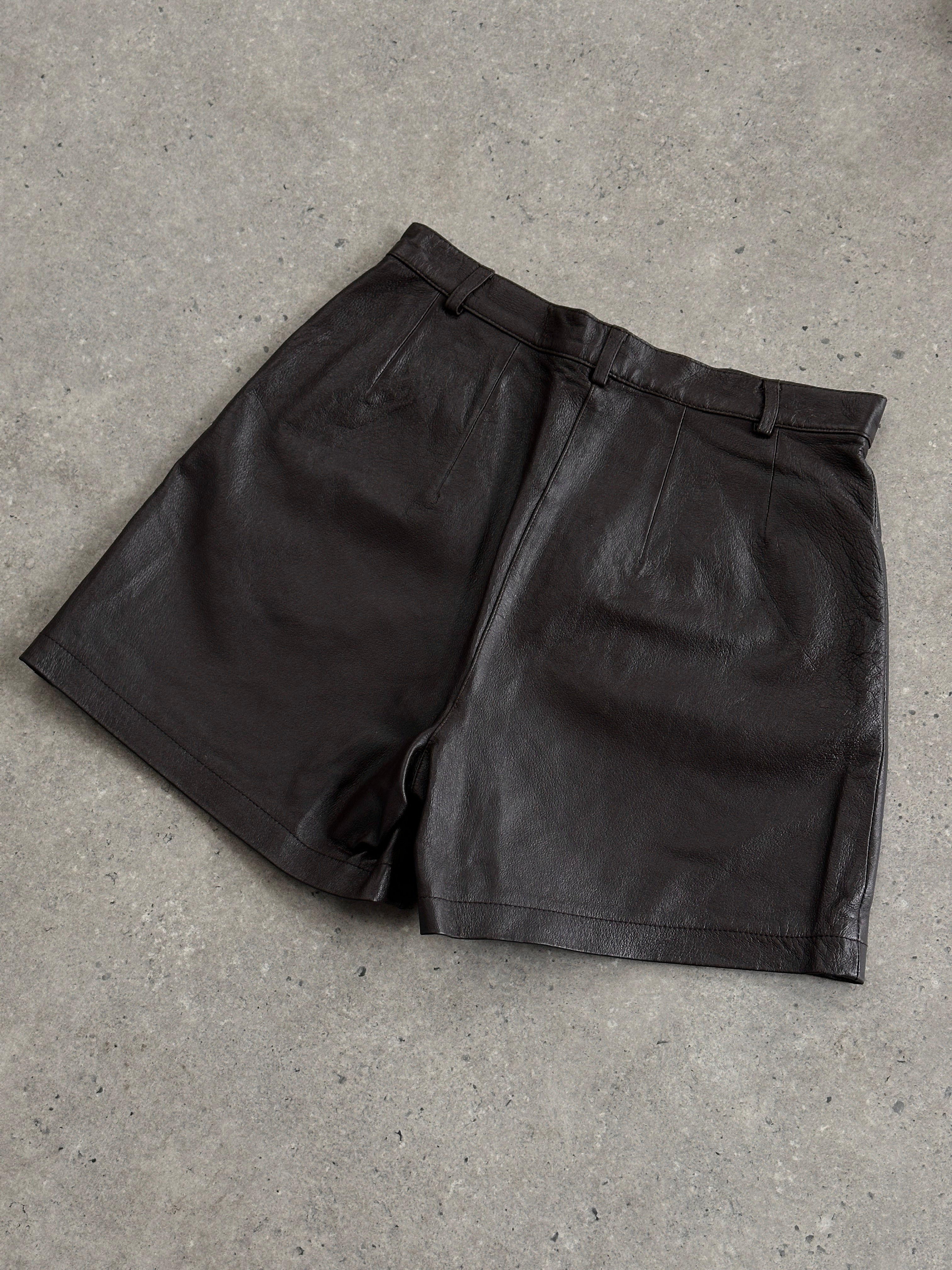 Vintage 2000s leather high-waisted mini shorts in W26, with a classic fit and stylish design, displayed on a neutral background.