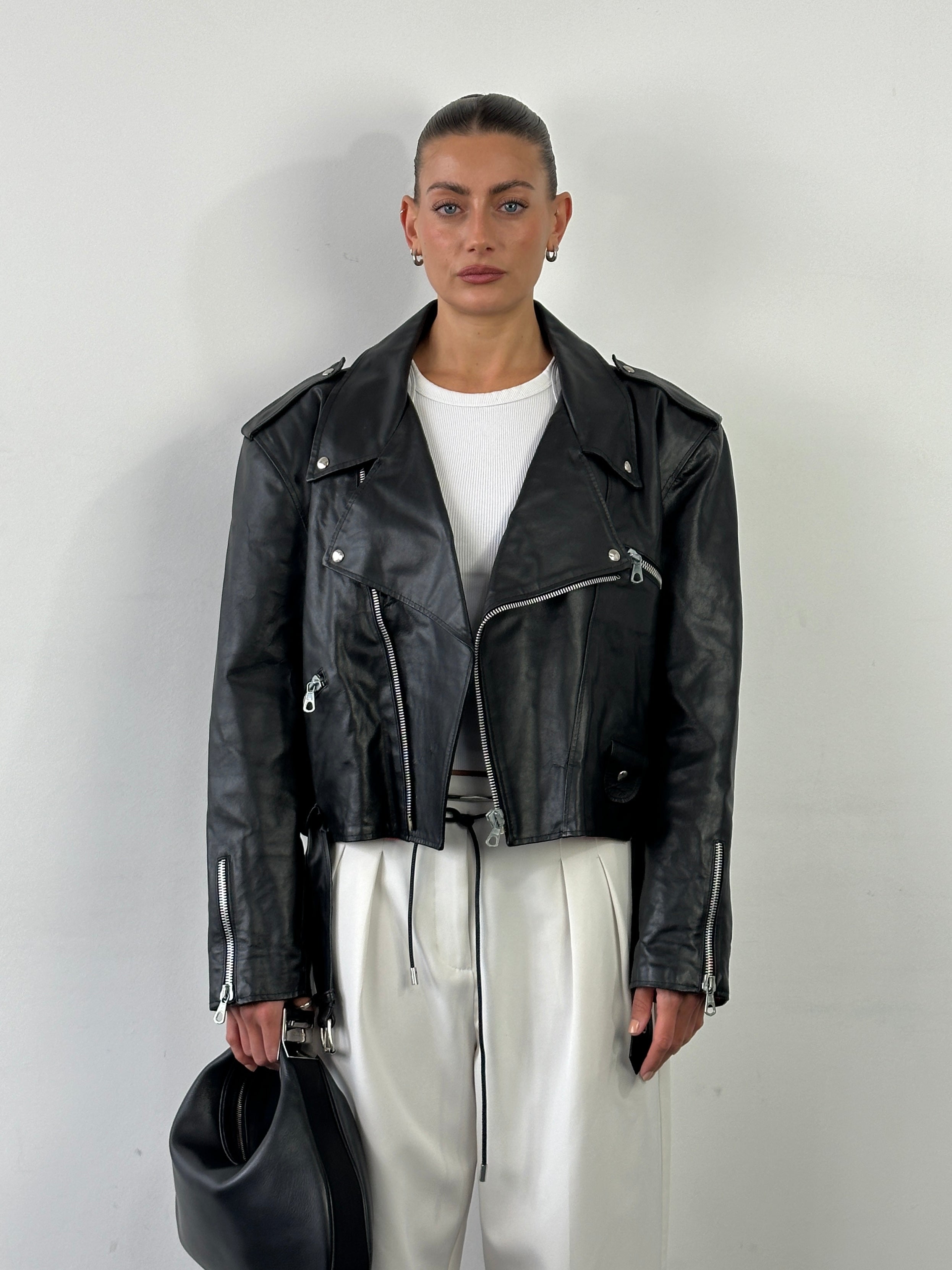 Vintage Italian vintage cropped leather biker jacket with lapel collar and metal hardware, size large, rugged and stylish design.