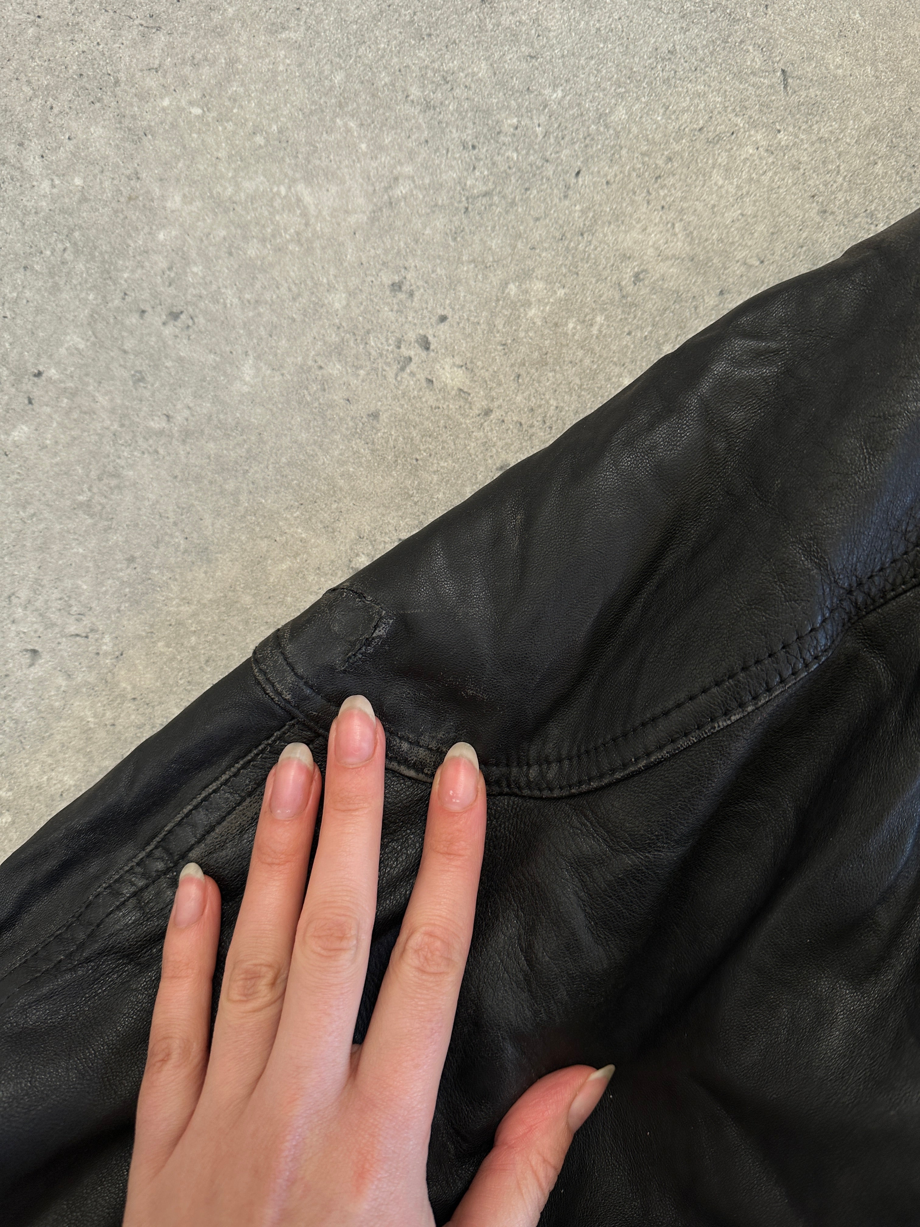 Vintage leather bomber jacket in size M, featuring classic design and rugged leather texture, displayed on a plain background.
