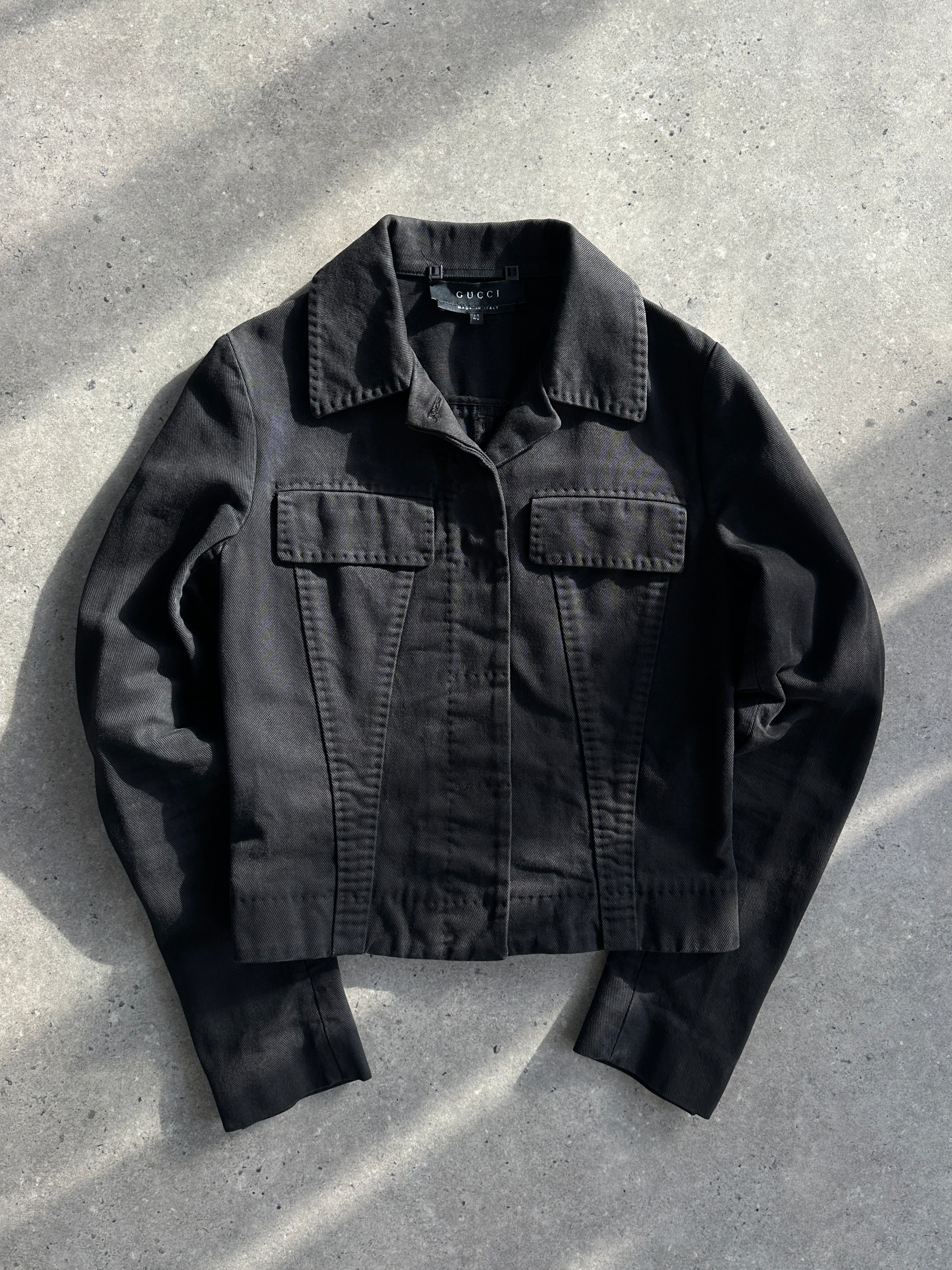 Gucci by Tom Ford 2002 fitted denim jacket in XS, shown on a hanger with classic blue denim and subtle stitching details.