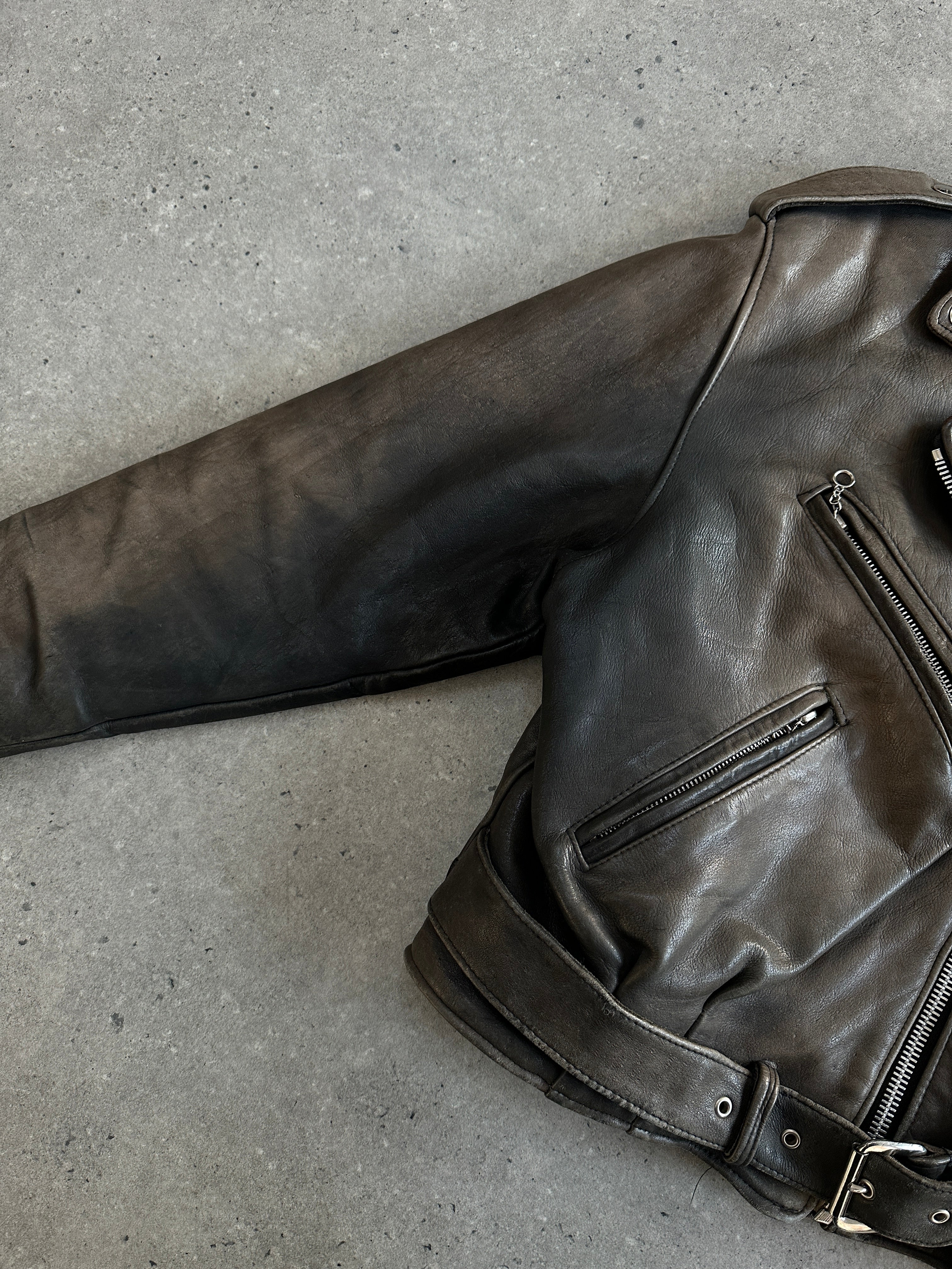 Vintage 1980s distressed leather biker jacket, size small, with rugged style and classic hardware details.