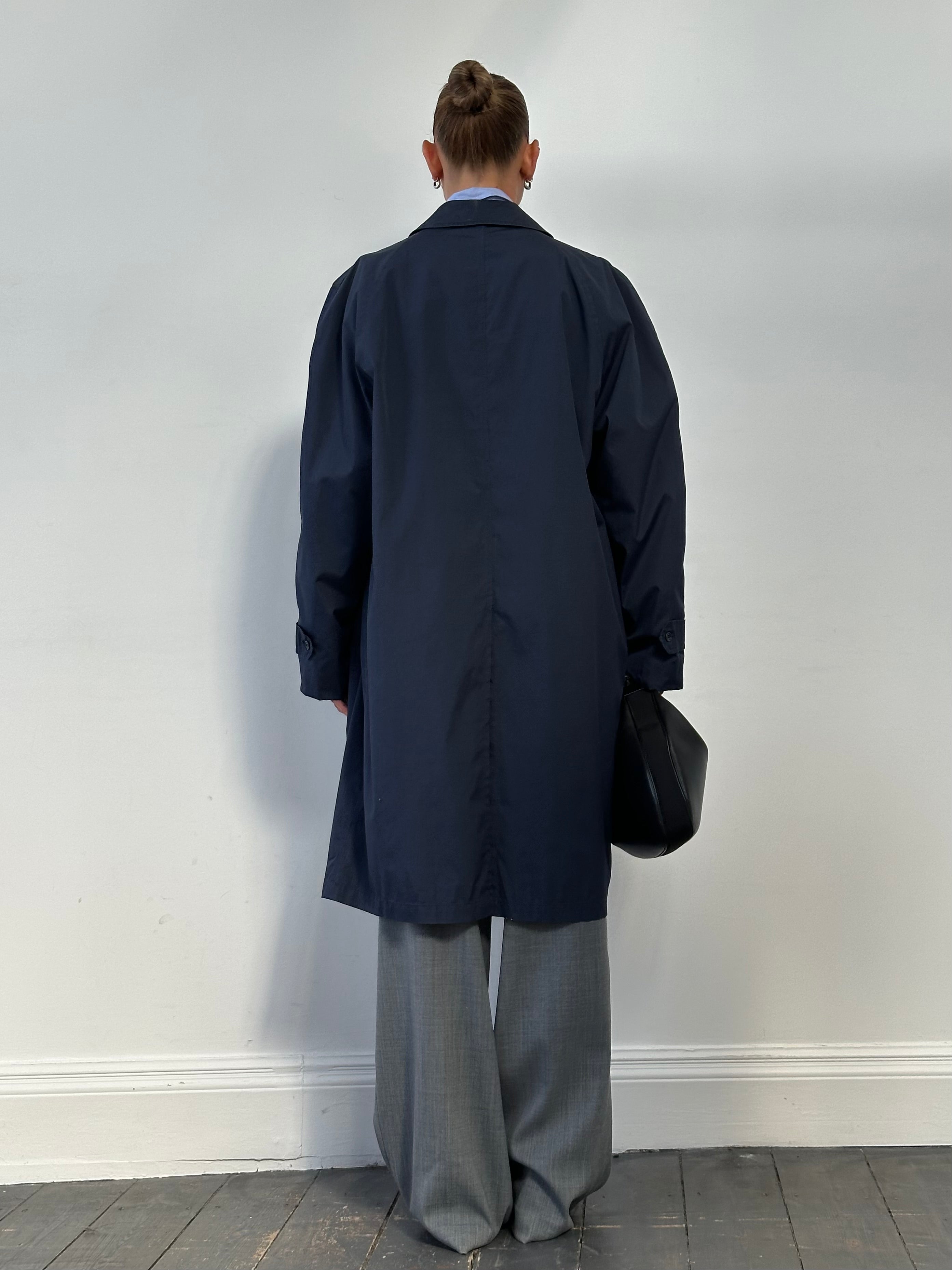 London Fog concealed placket trench coat in XL displayed on a hanger, featuring classic beige color and tailored design.