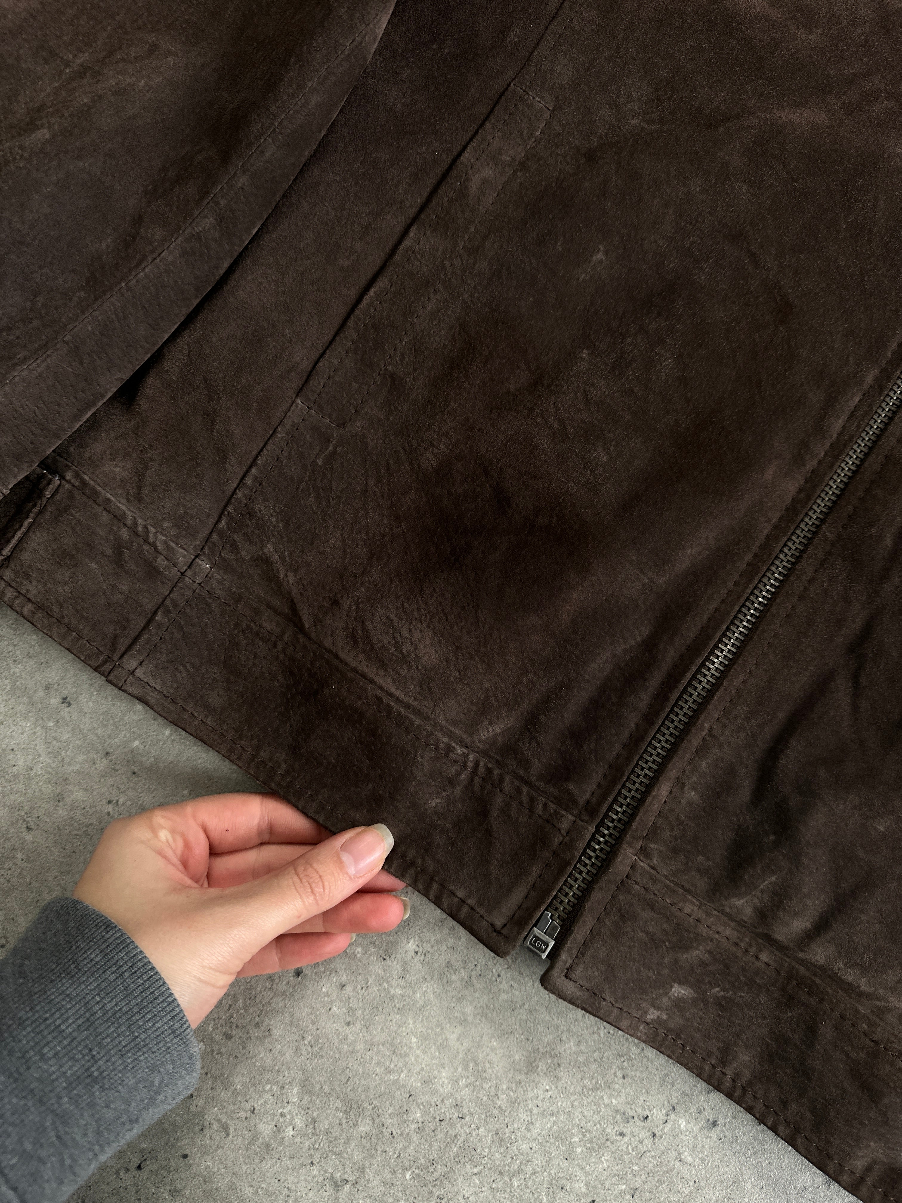 Vintage suede zip-up jacket in size L displayed on a hanger, showcasing its classic design and rich texture.