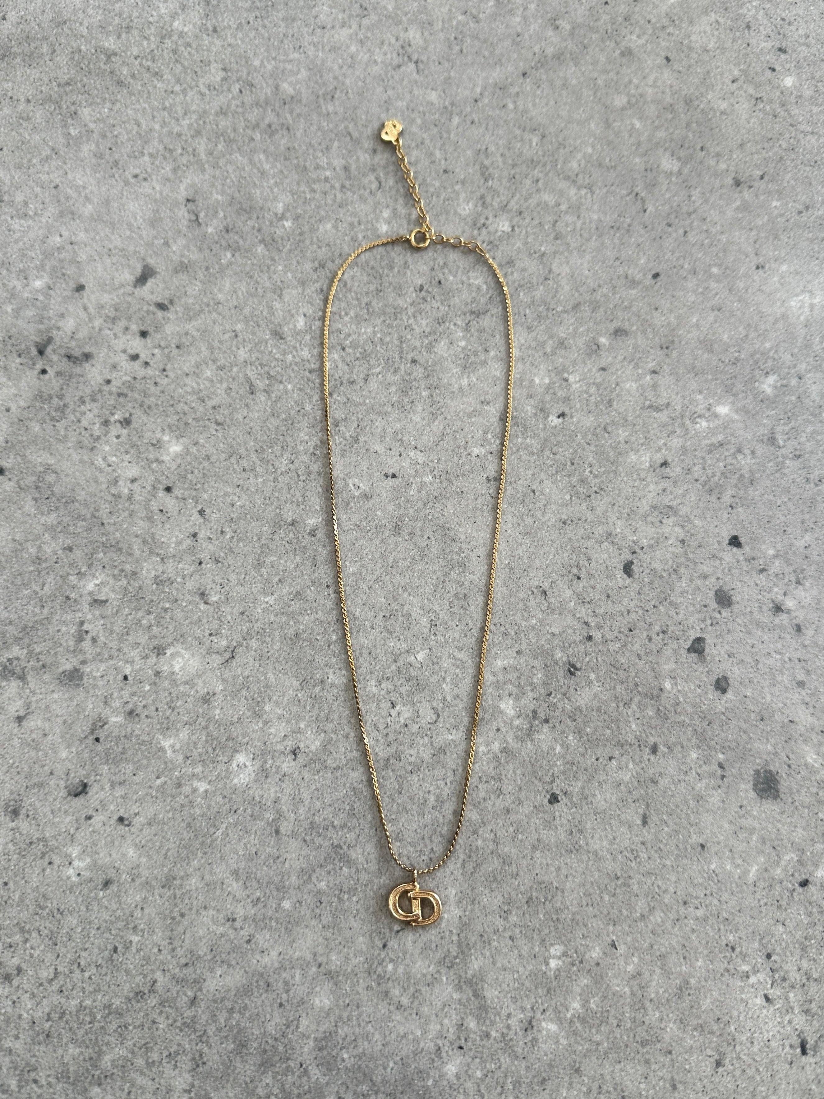 Christian Dior 1990s gold plated CD logo pendant necklace featuring a 16-inch chain and iconic Dior branding.