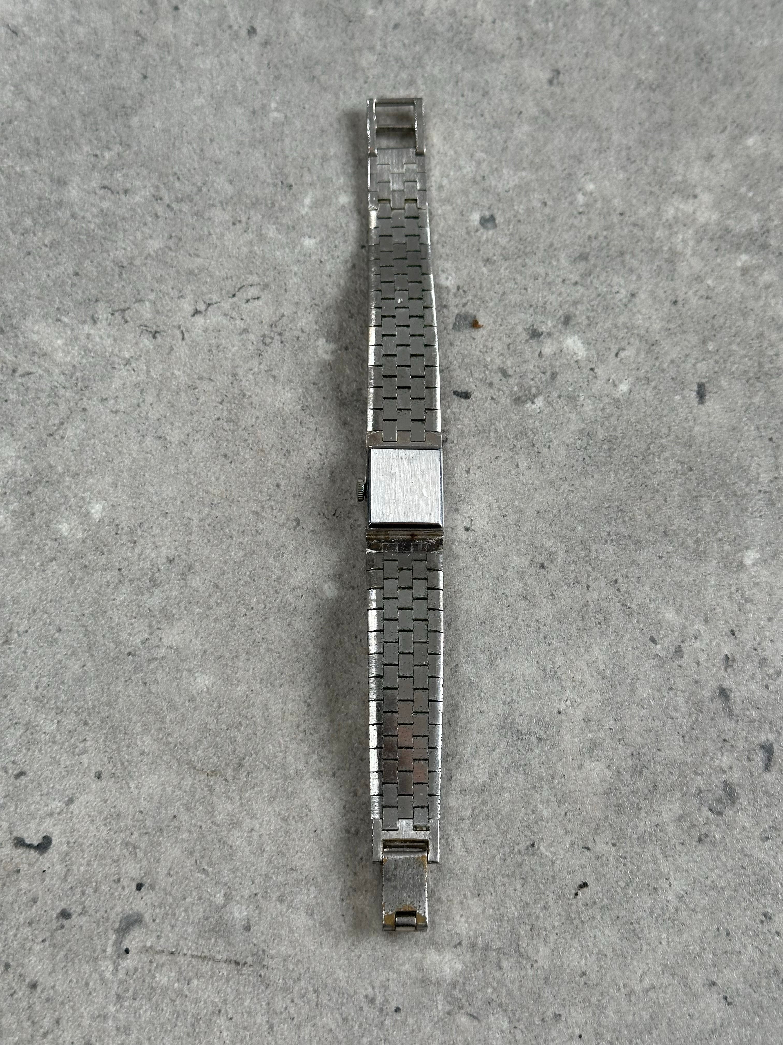 Vintage 1970s stainless steel square dial watch with minimalist design and metal bracelet, showcasing classic vintage style.