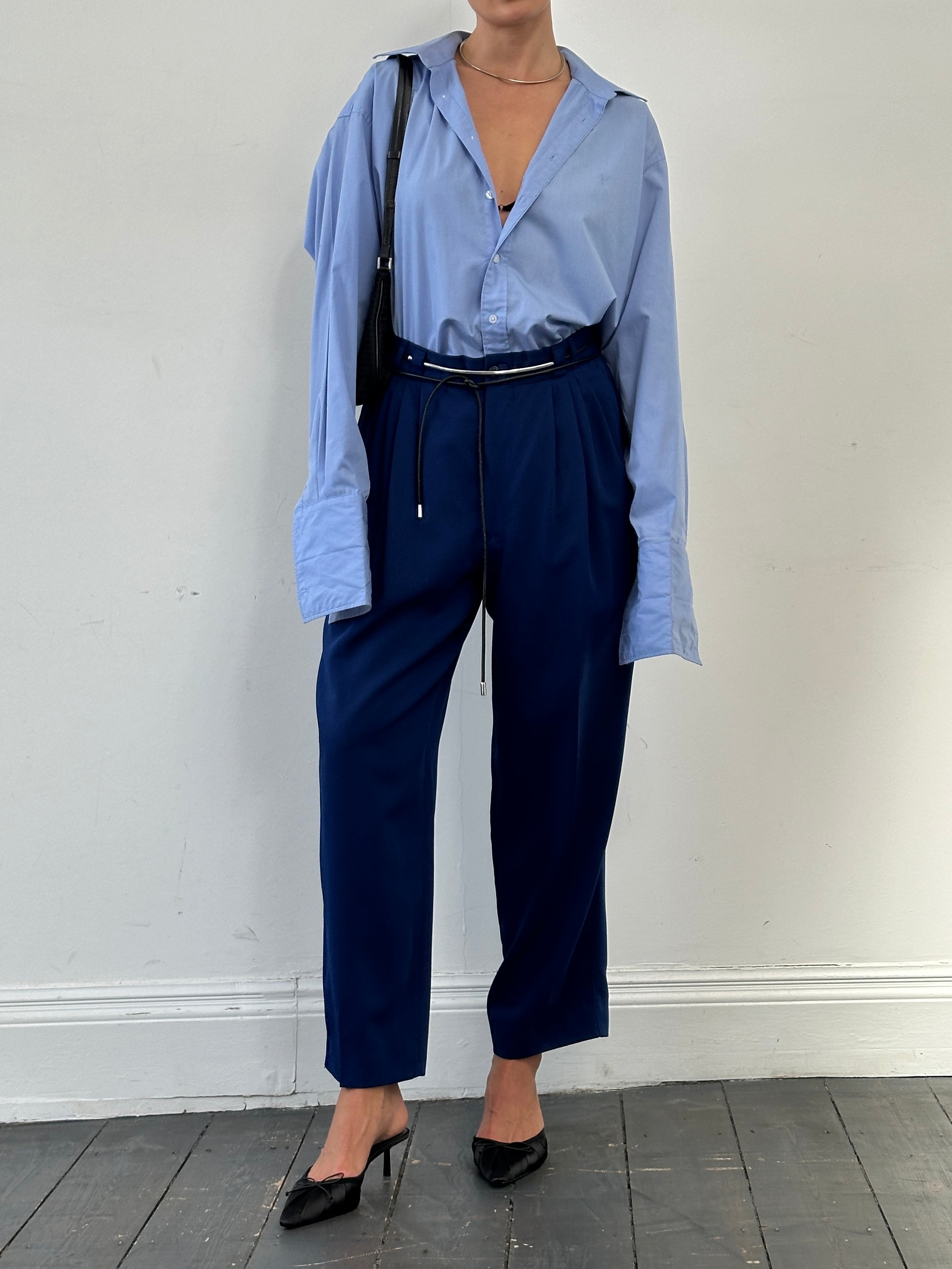 Versace Classic V2 wool pleated high-waisted tailored trousers in navy, shown on model, with crisp pleats and sleek fit.