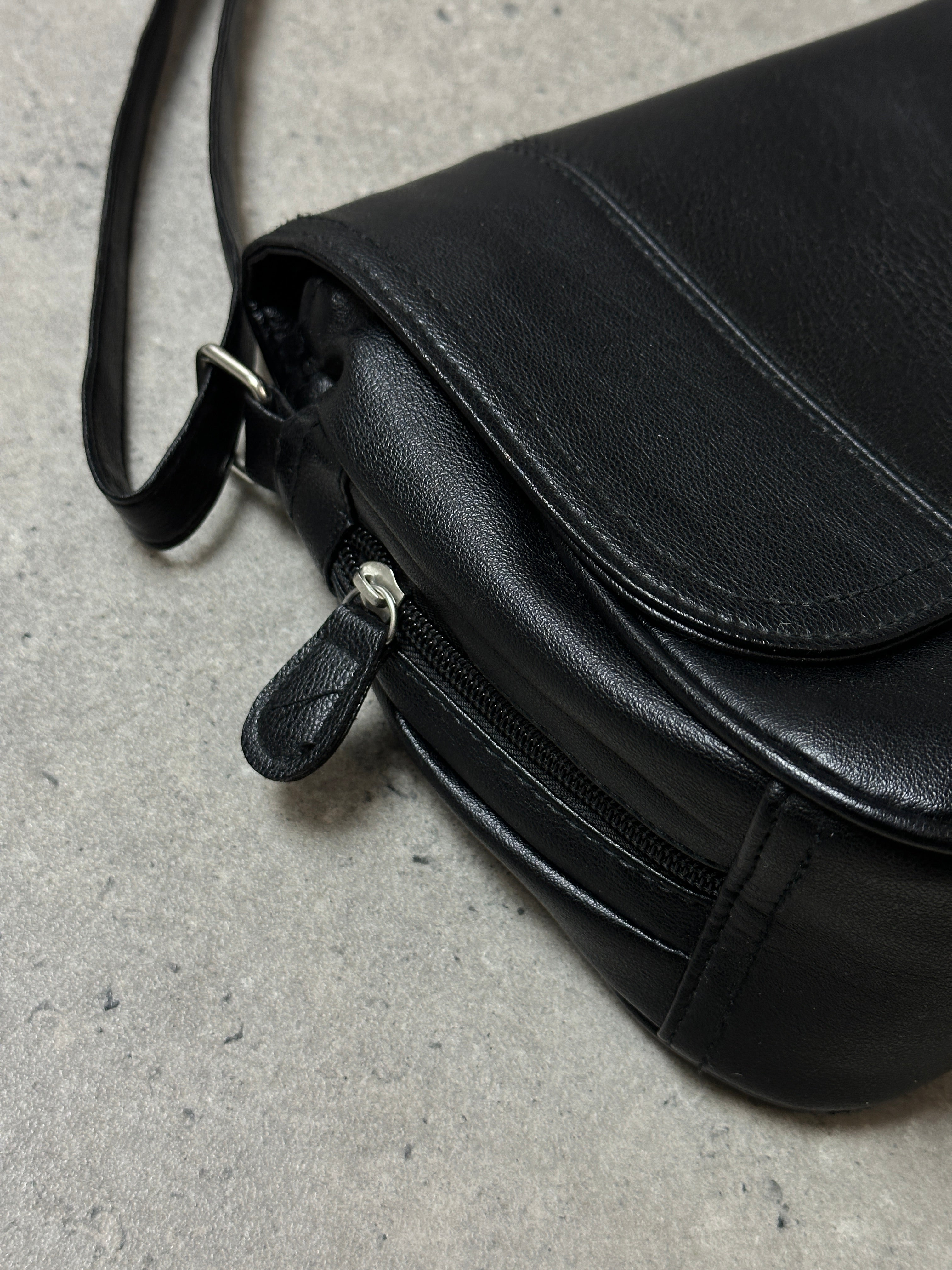 Vintage faux leather crossbody bag with adjustable strap and metal hardware, featuring a classic vintage style.