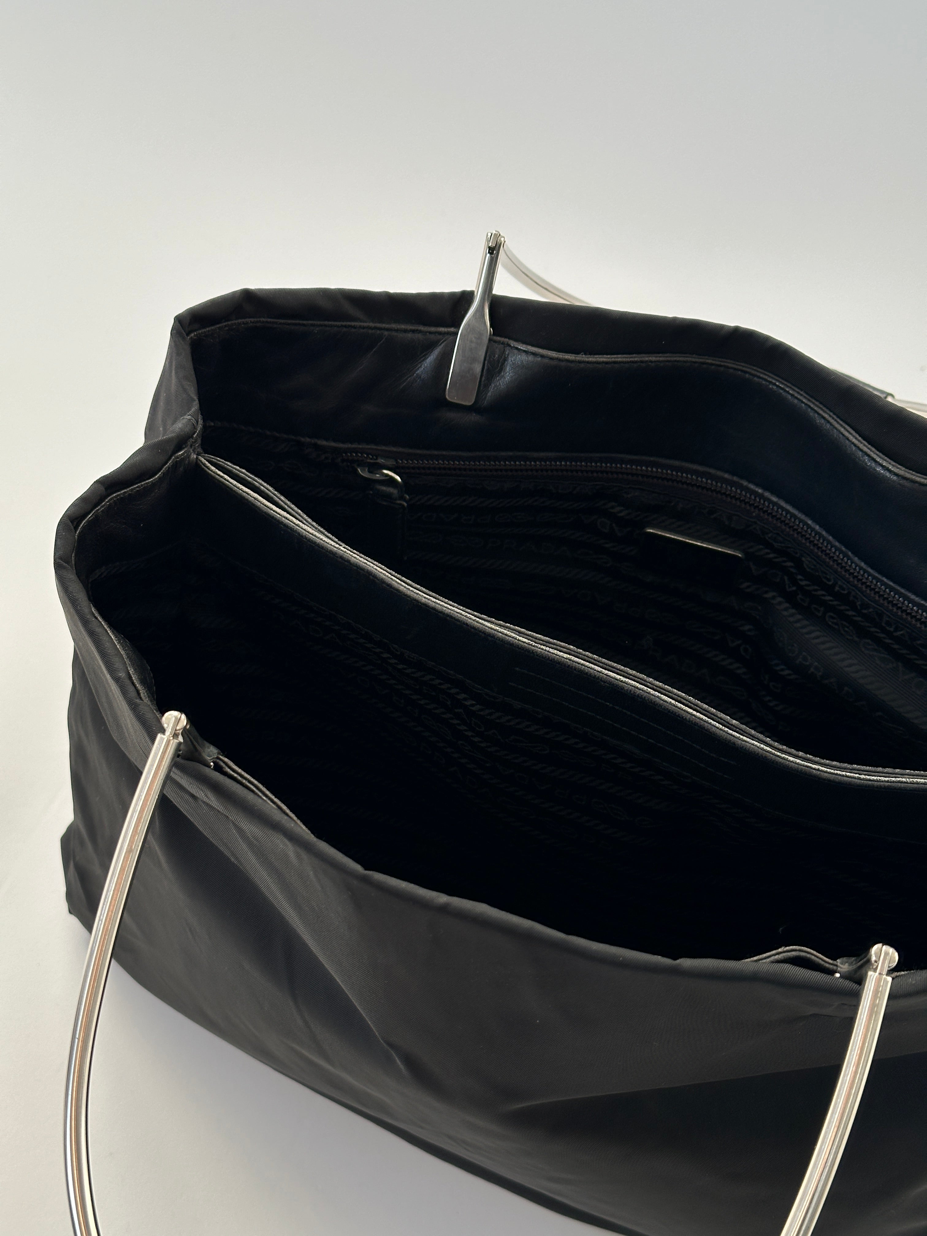 Prada nylon leather tote bag with sleek design, featuring sturdy handles and spacious interior for everyday use.