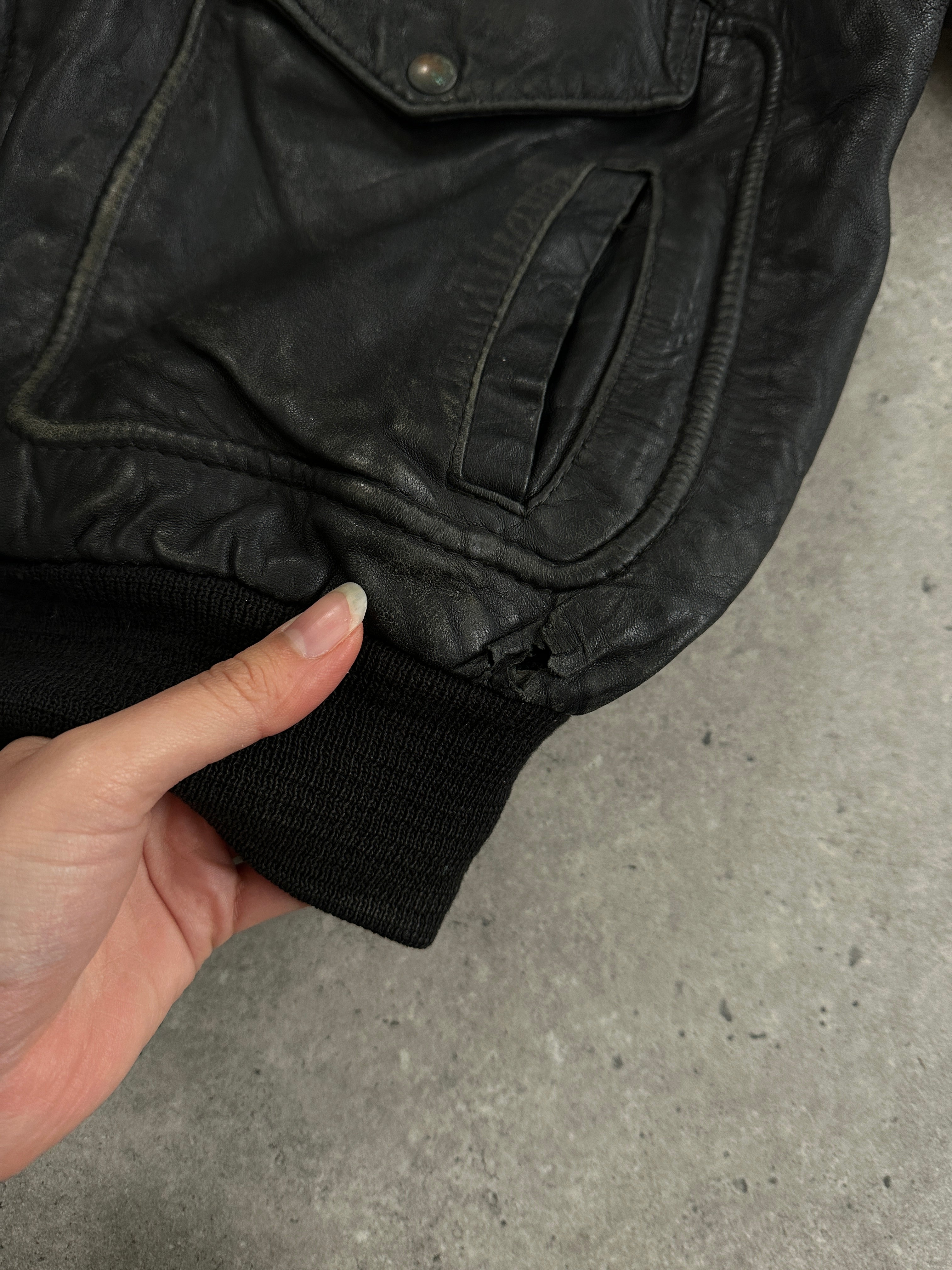 Vintage distressed leather bomber jacket in XL size, featuring a rugged design and classic style with visible stitching and worn finish.