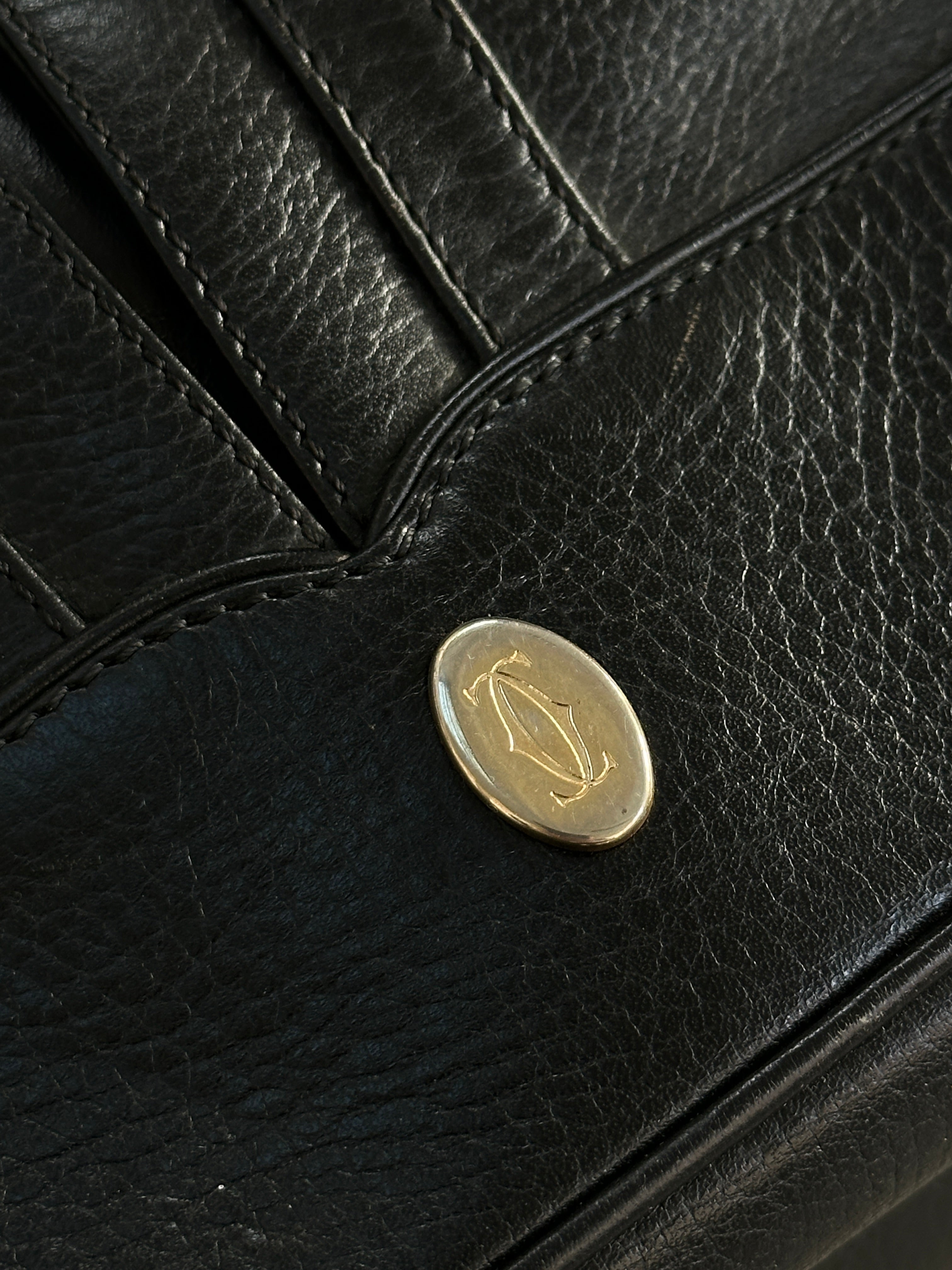 Cartier 1980s leather bucket bag with drawstring closure and shoulder strap, featuring classic designer craftsmanship.
