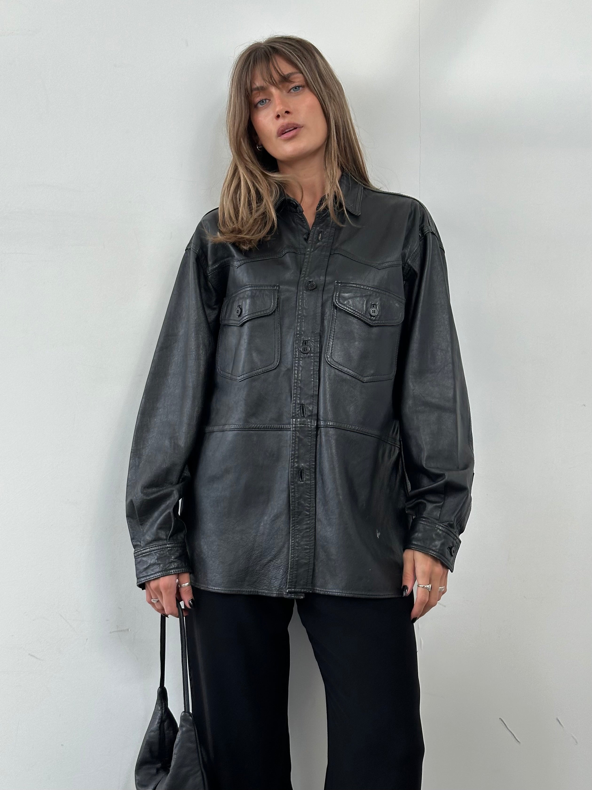 Vintage leather shirt in size L/XL, featuring classic design and rich texture, displayed on a neutral background.
