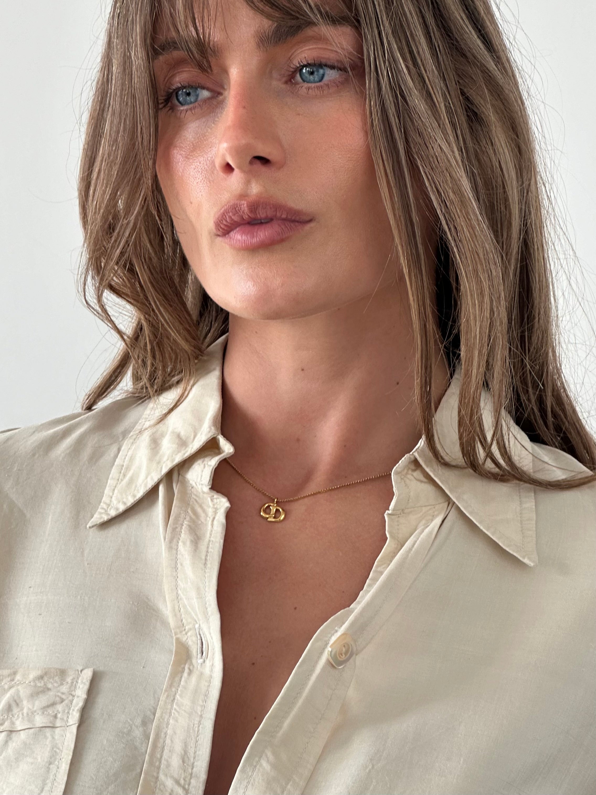Christian Dior 16-inch gold plated logo pendant necklace with sleek chain and prominent Dior emblem.