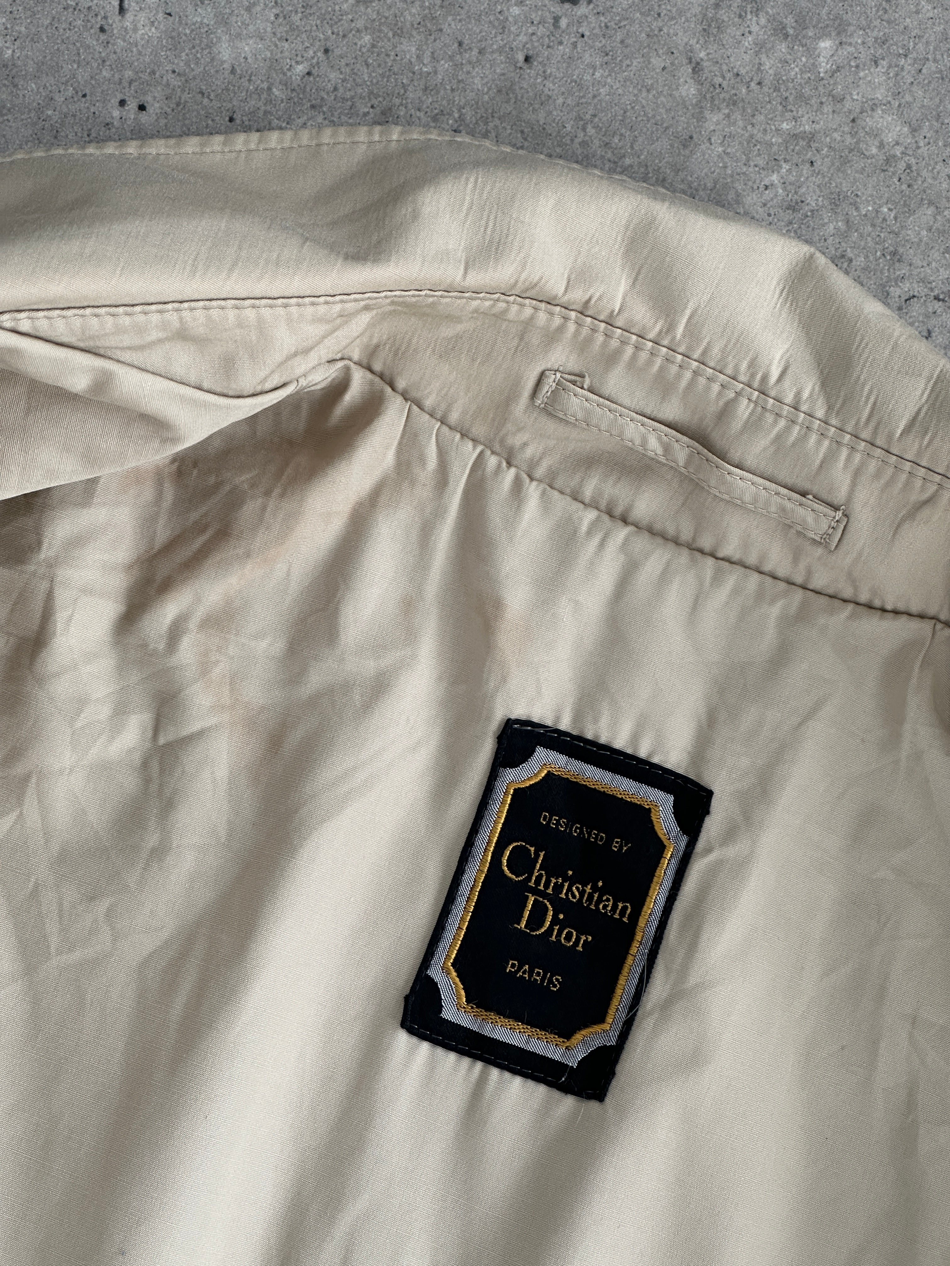 Christian Dior Paris cotton double-breasted belted trench coat in beige, featuring a classic collar and button details.